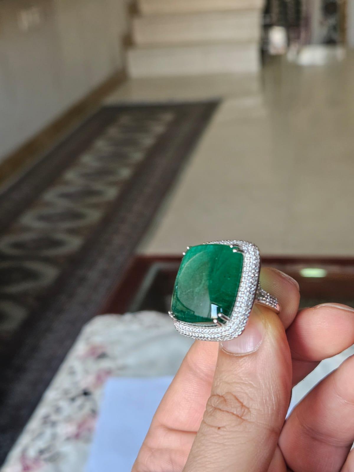 Un anello di fidanzamento con smeraldo molto speciale e bello, in stile moderno, con oro bianco 18 carati e diamanti naturali. Il peso dello smeraldo piatto cabochon è di 23,55 carati. Lo Smeraldo è completamente naturale, senza alcun trattamento ed