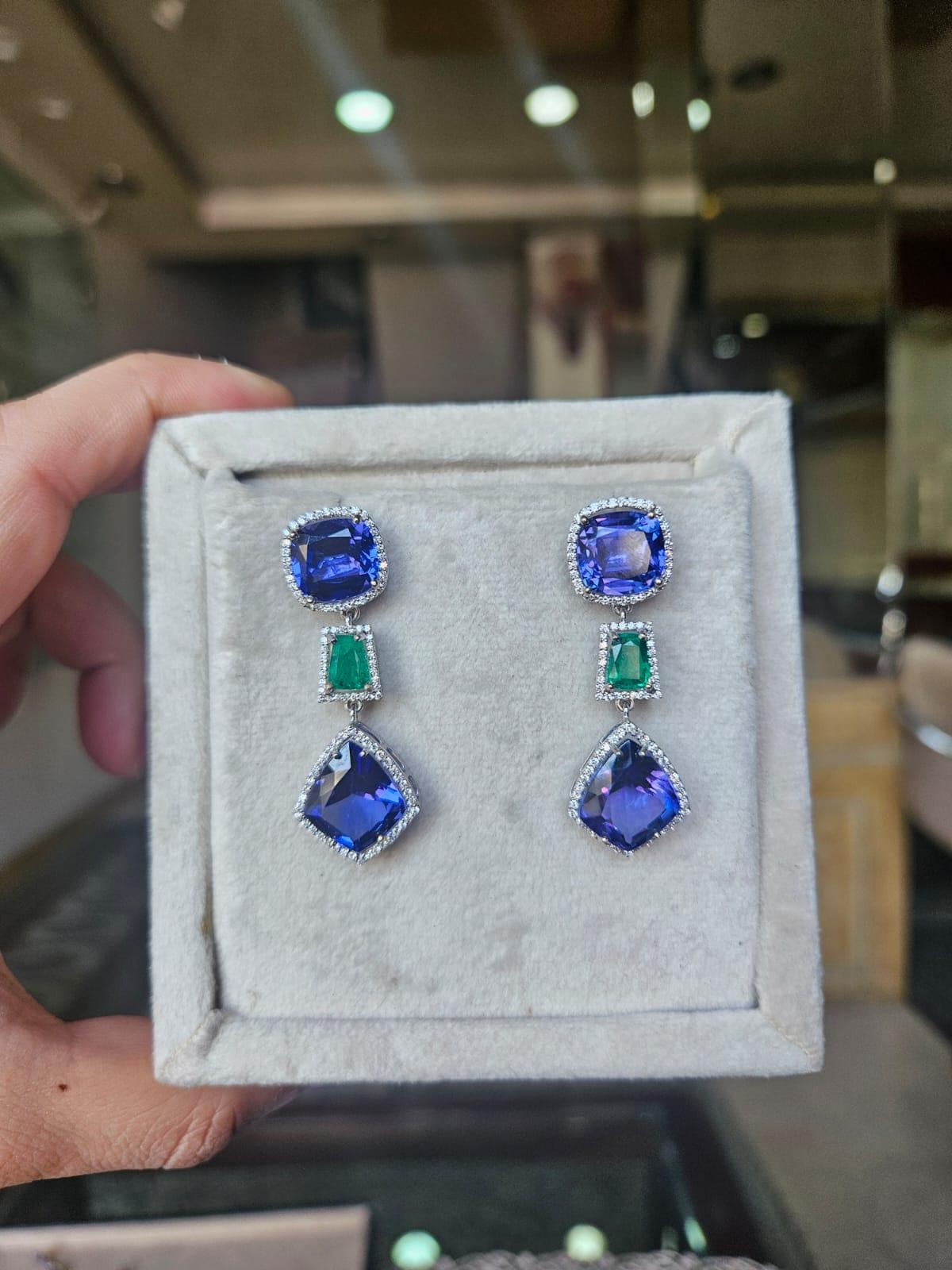 Très belles boucles d'oreilles pendantes en or blanc 18 carats et diamants naturels avec émeraudes et tanzanites, de style moderne. Le poids total des tanzanites est de 23.71 carats. Les tanzanites proviennent de Tanzanie. Le poids des émeraudes est