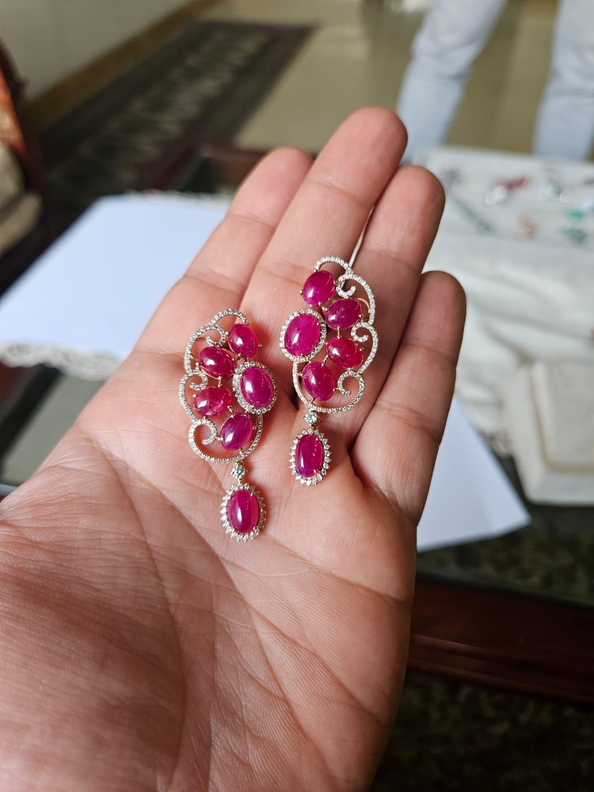 Bellissimi orecchini pendenti di rubino in oro 18 carati e diamanti naturali, dallo stile moderno. Il peso dei rubini è di 24.87 carati. I cabochon di rubino sono completamente naturali, senza alcun trattamento e sono di origine mozambicana. Il peso