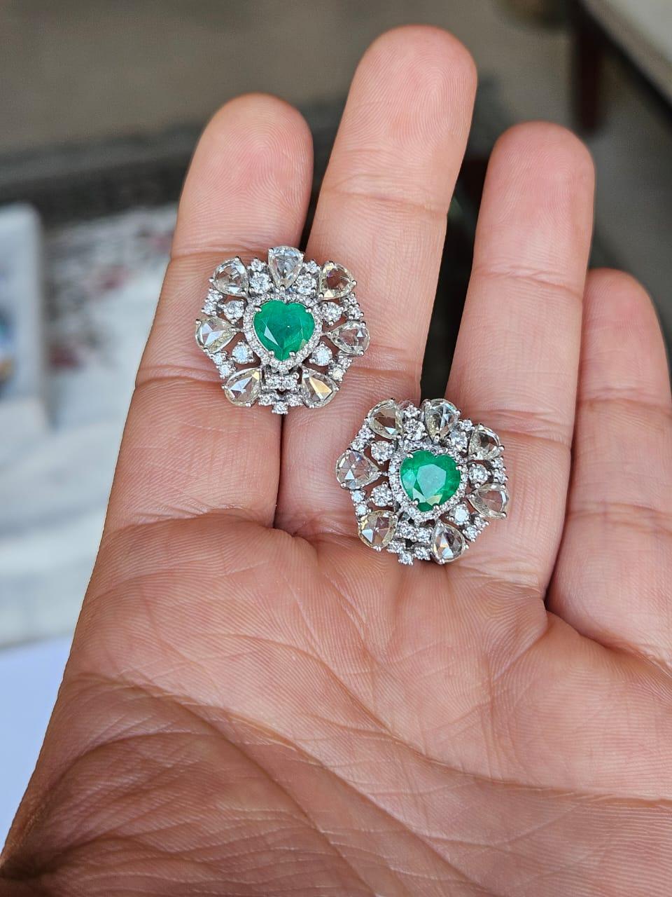A very gorgeous and beautiful, modern style, Emerald Stud Earrings set in 18K White Gold & natural Diamonds. The weight of the heart shaped Emeralds is 2.67 carats. The Emerald are completely natural, without any treatment and are of Zambian origin.