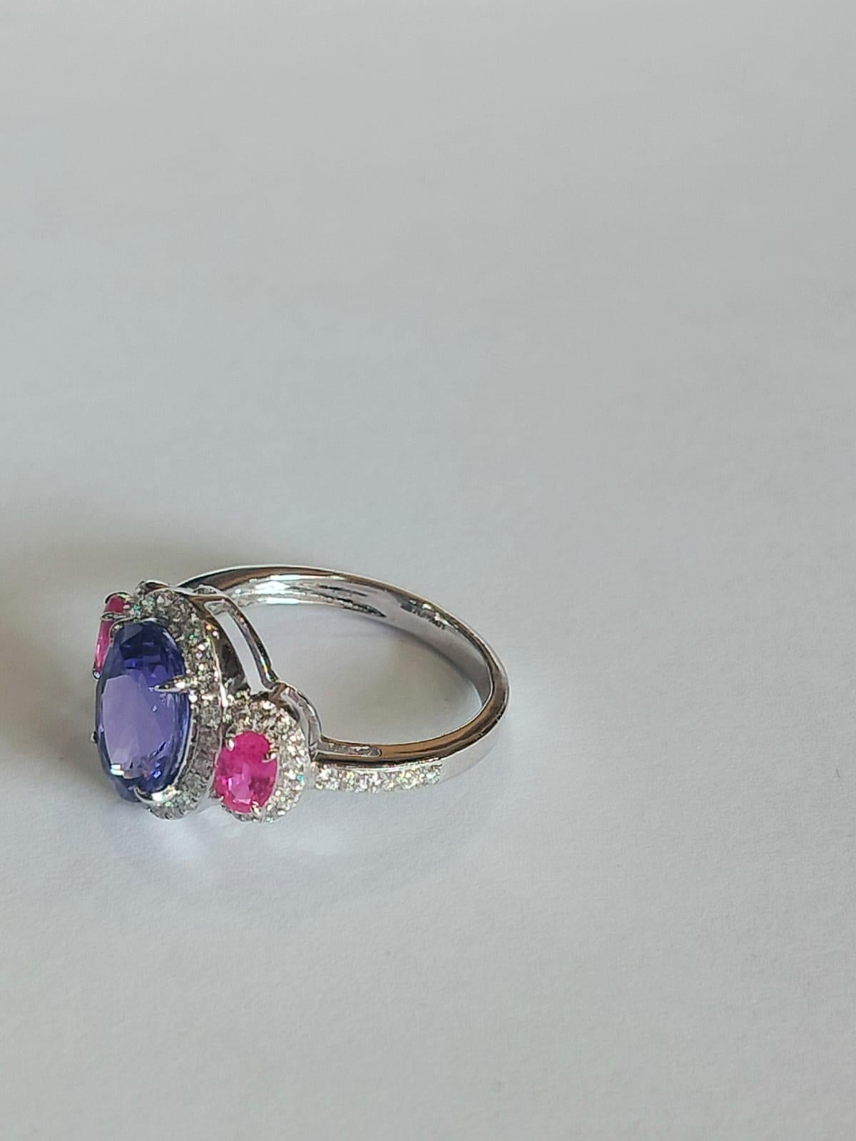 A very gorgeous and modern, Tanzanite and Pink Sapphire Engagement Ring set in 18K Gold & Diamonds. The weight of the Tanzanite is  2.90 carats. The Tanzanite is responsibly sourced from Tanzania. The weight of the Pink Sapphires is 0.65 carats. The