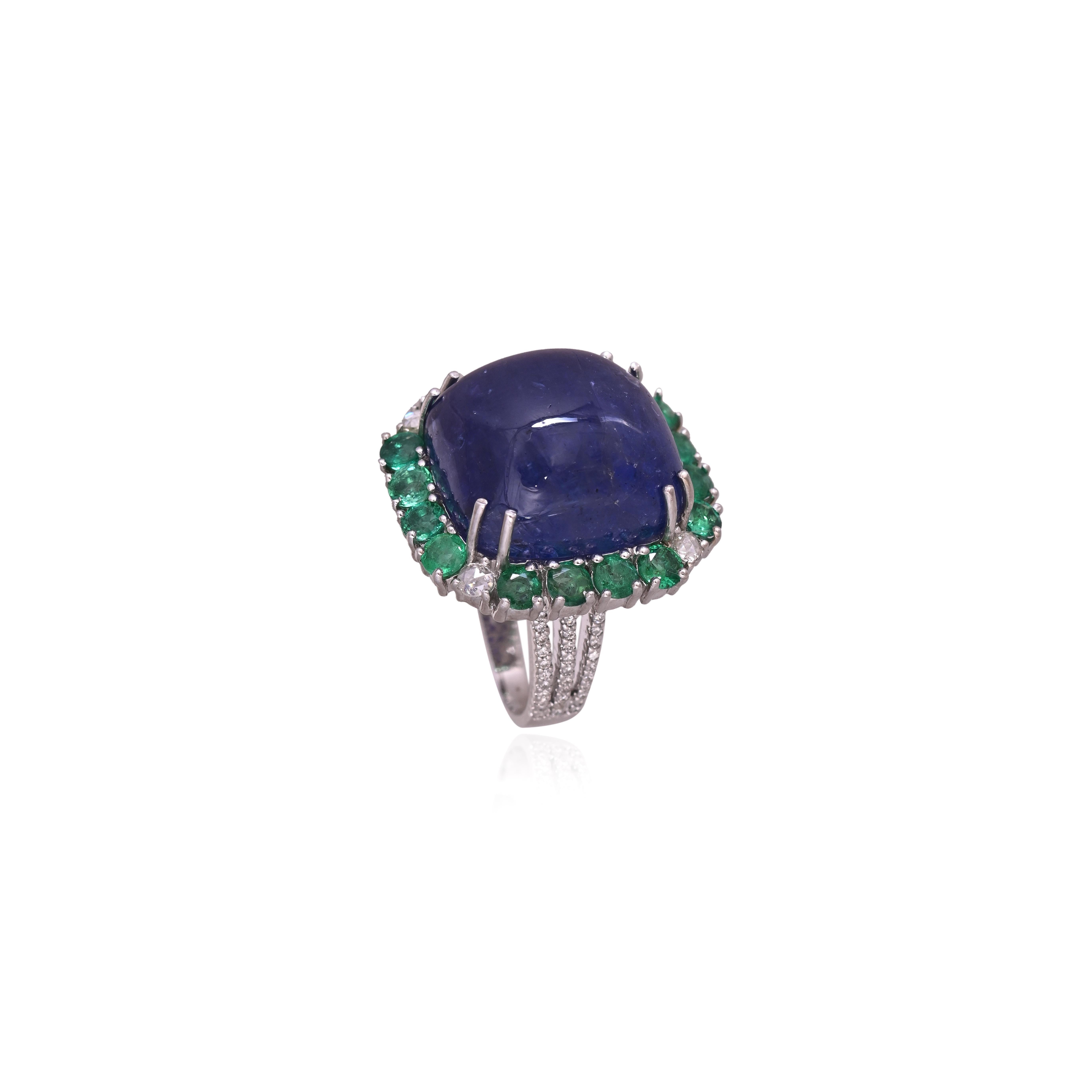 Un anello da cocktail con tanzanite e smeraldo in oro 18 carati e diamanti naturali. Il peso della tanzanite cabochon è di 32,53 carati. La tanzanite proviene in modo responsabile dalla Tanzania. Il peso degli smeraldi è di 2,32 carati. Gli smeraldi