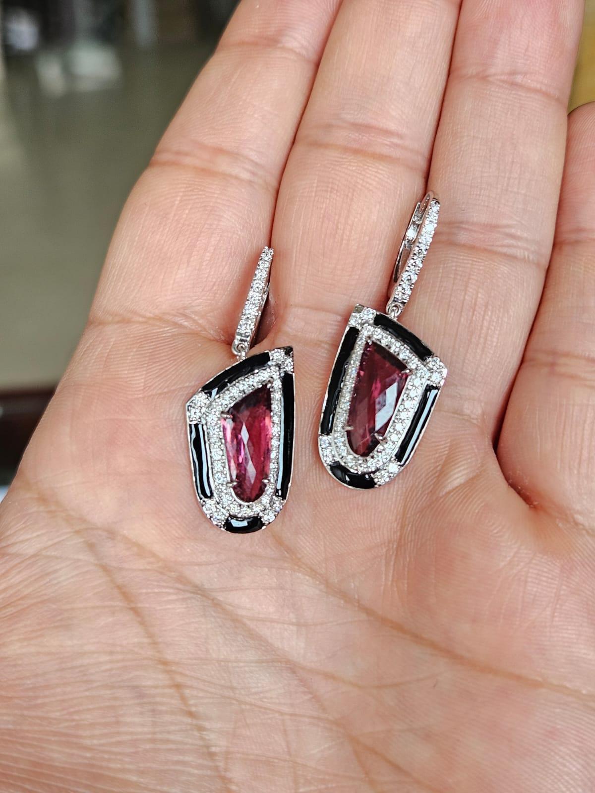 Unos preciosos pendientes colgantes de rubelita y esmalte negro, de estilo Art-Deco, engastados en oro blanco de 18 quilates y diamantes naturales. El peso de las Rubelitas facetadas es de 3,48 quilates. El peso de los diamantes es de 0,84 quilates.