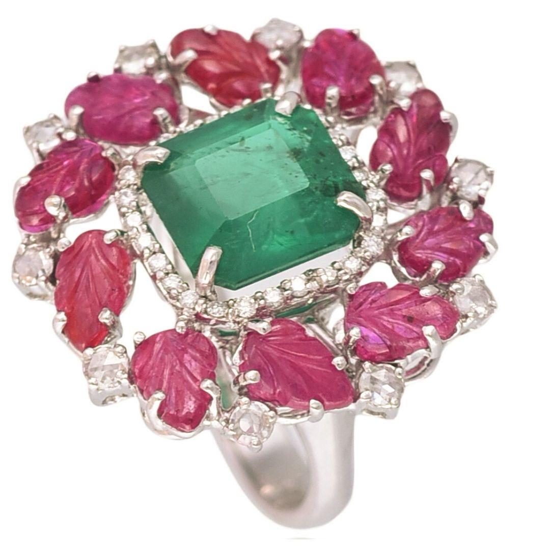 A one of its kind, Zambian Emerald & carved Ruby Cocktail Ring set in 18K Gold and Diamonds. The weight of the Emerald is 3.66 carats. The Emerald is of Zambian origin and is without any treatment. The weight of the carved Rubies is 3.68 carats. The