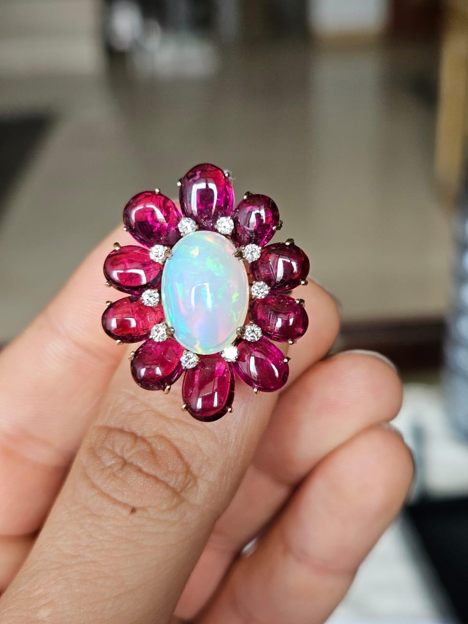 Magnifique bague cocktail en or rose 18 carats et diamants naturels, ornée d'une opale et d'une tourmaline. Le poids du cabochon d'opale est de 4.39 carats. L'opale est d'origine éthiopienne et présente un jeu de couleurs orange et vert. Le poids