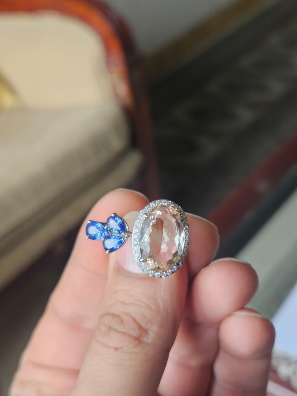 Très belle bague cocktail de style moderne en or rose 18 carats et diamants naturels, ornée de Morganite et de Saphirs bleus. Le poids de la Morganite est de 4.78 carats. Le poids des saphirs bleus est de 1.48 carats. Les saphirs bleus sont