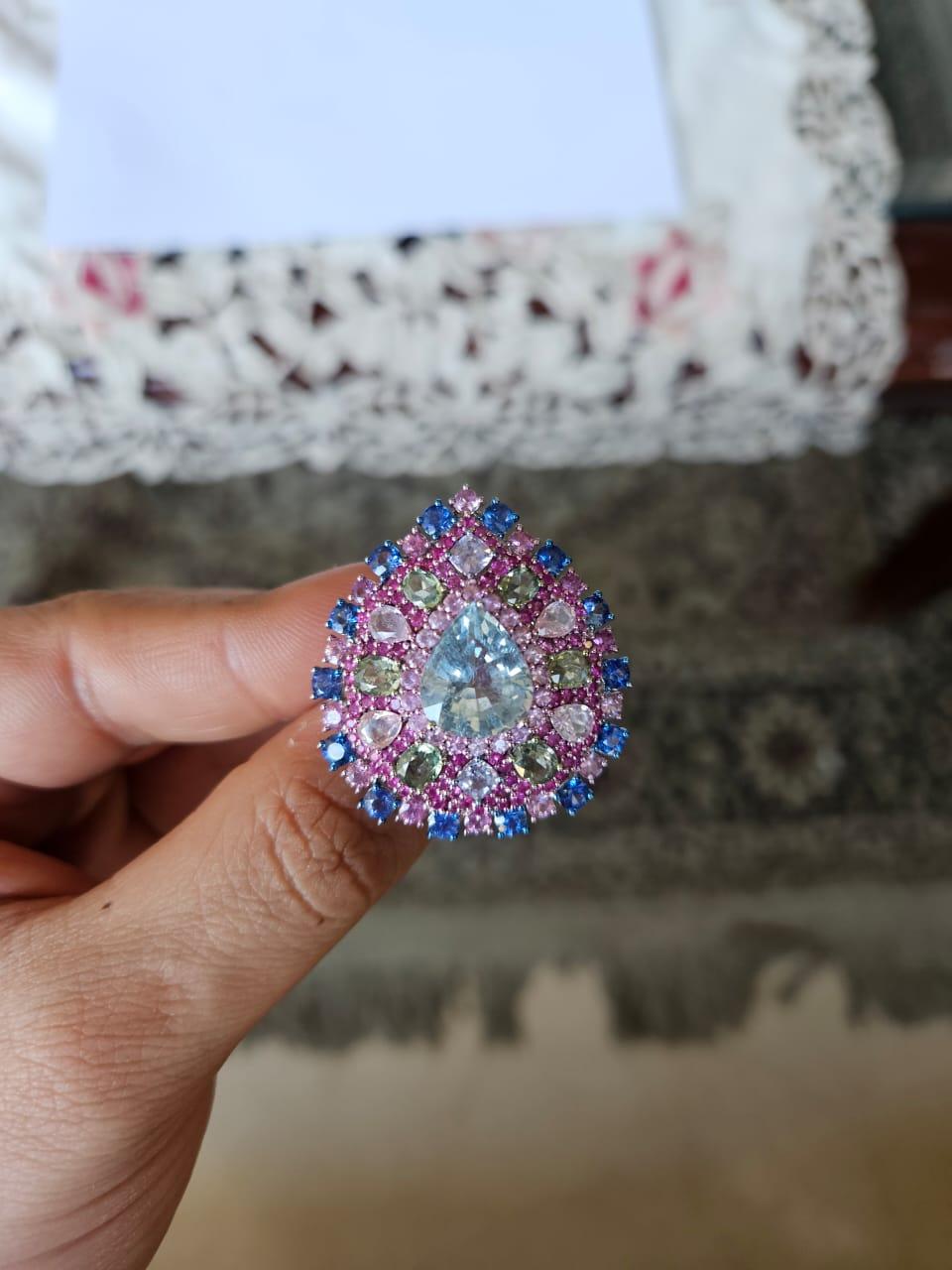 A very gorgeous and beautiful, one of a kind, modern style, Aquamarine & Multi Sapphires Cocktail Ring set in 18K White Gold & natural Diamonds. The weight of the pear shaped Aquamarine is 4.89 carats. The weight of the Multi Sapphires is 7.08