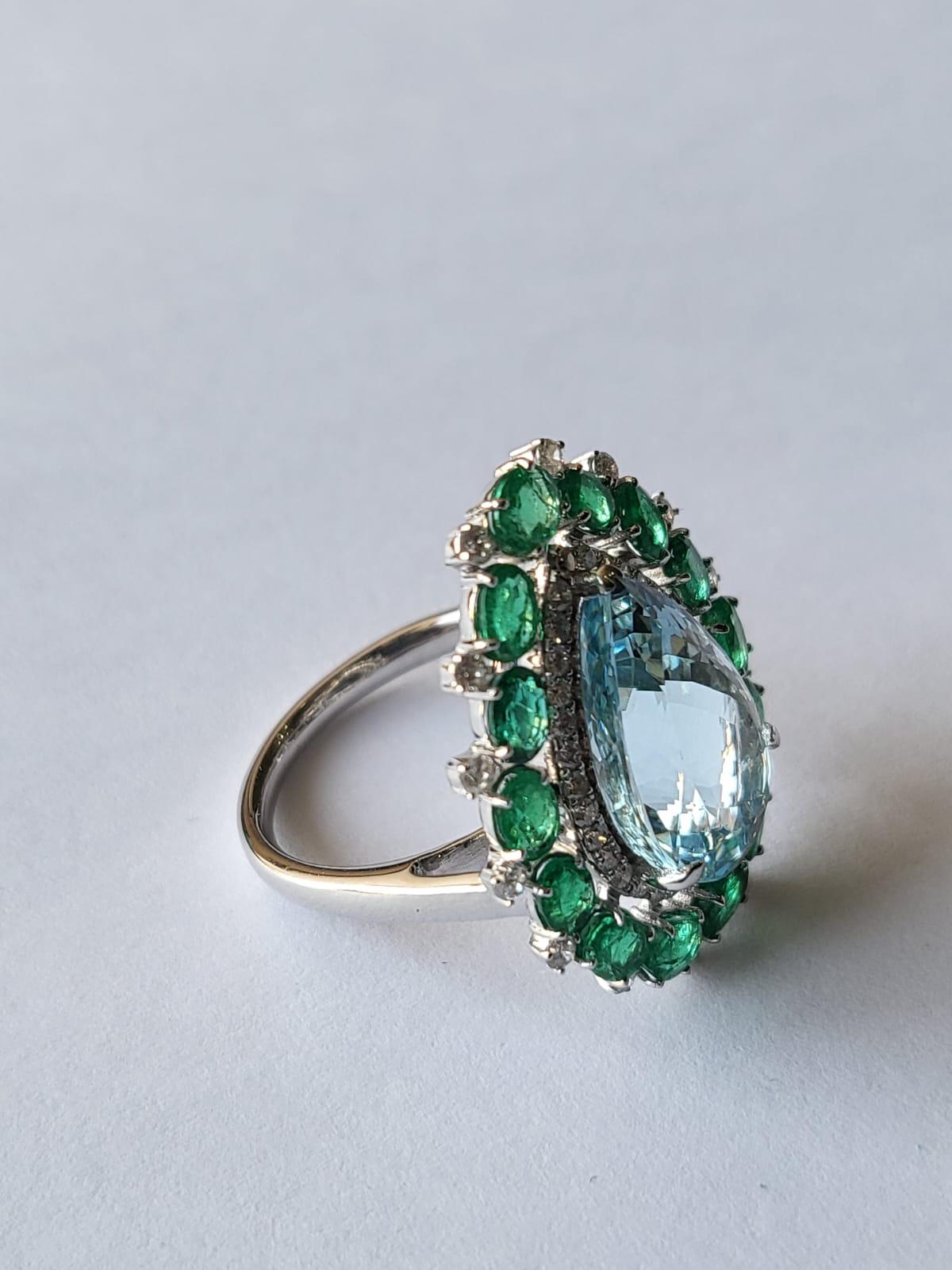 A very gorgeous and one of a kind, Aquamarine & Emerald Cocktail / Engagement Ring set in 18K White Gold & Diamonds. The weight of the pear shaped Aquamarine is 5.51 carats. The weight of the Emeralds is 2.10 carats. The Emeralds are completely