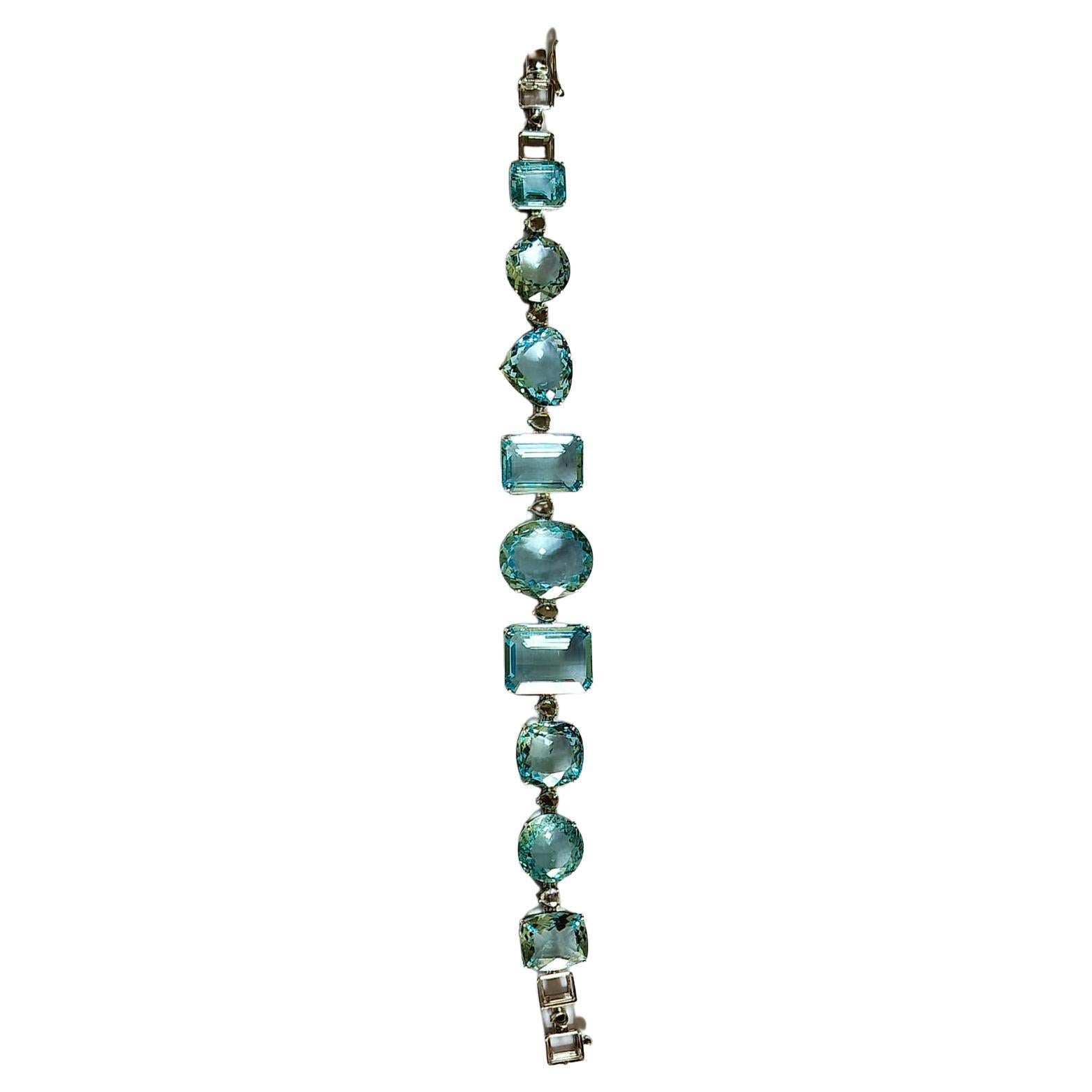A very gorgeous, fun yet classic Aquamarine Tennis Bracelet set in 18K Gold & Diamonds. The weight of the Mixed shaped Aquamarine is 57.57 carats. The Aquamarine are completely natural, without any treatment . The weight of the Diamonds is 0.8