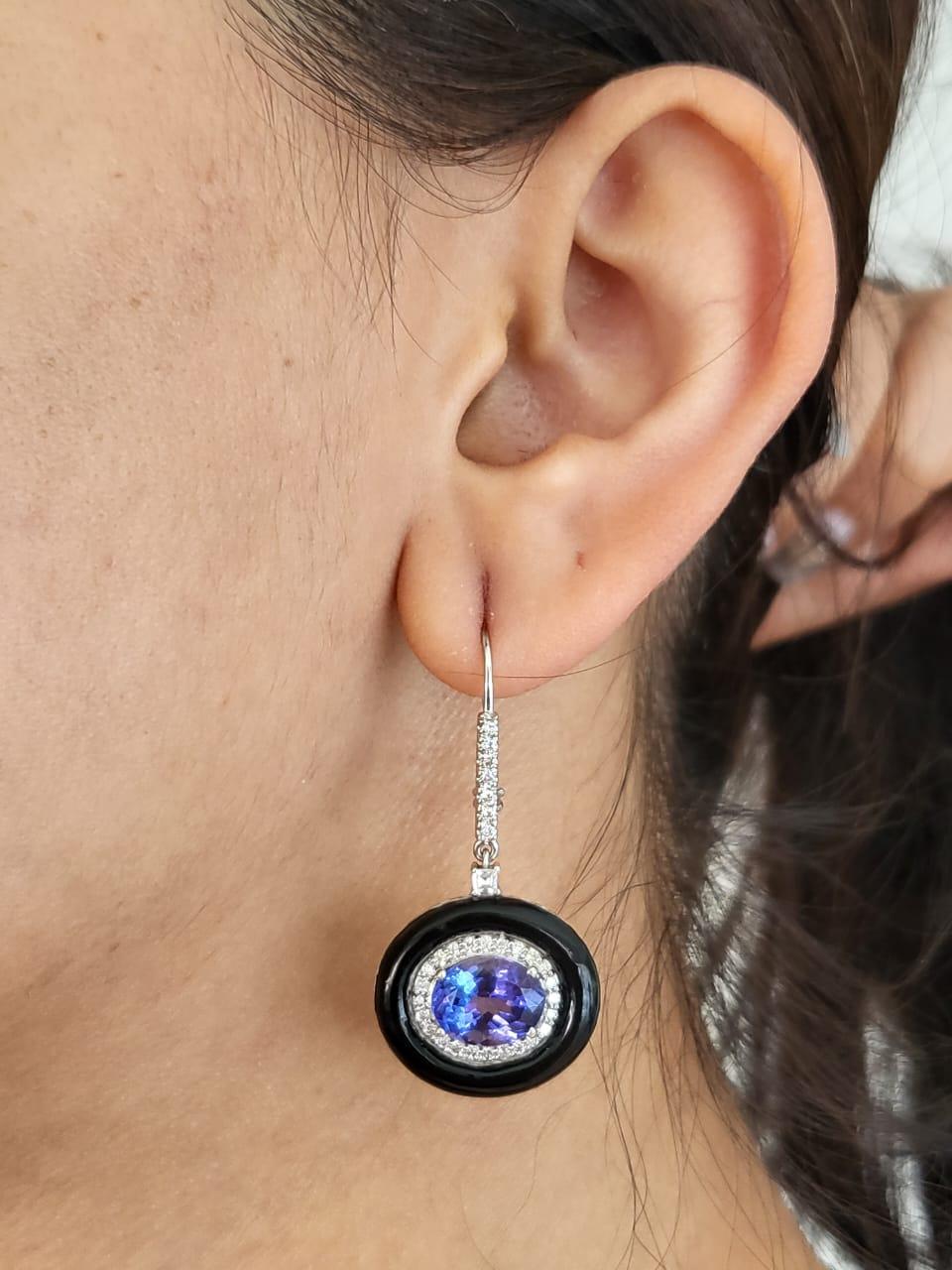 A very gorgeous, Art deco style, Tanzanite & Enamel Dangle Earrings set in 18K White Gold & Diamonds. The weight of the Tanzanite ovals is 6.43 carats. The Tanzanite is responsibly sourced from Tanzania. The weight of the Diamonds is 0.71 carats.