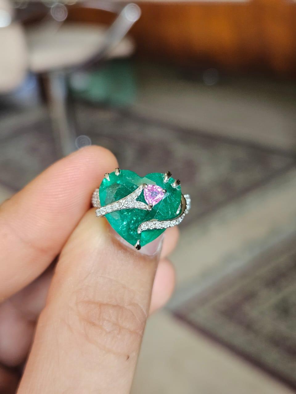 A very gorgeous and beautiful, modern style, Emerald & Pink Sapphire Engagement Ring set in 18K White Gold &b natural Diamonds. The weight of the Emerald is 6.74 carats. The Emerald is completely natural, without any treatment and is of Zambian