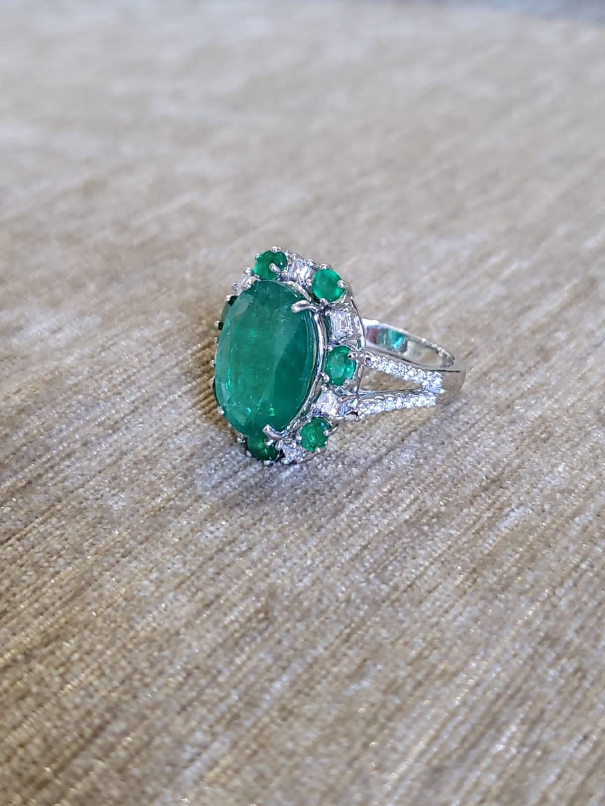 A very gorgeous and one of a kind, Emerald Engagement/ Cocktail Ring set in 18K White Gold & Diamonds. The weight of the centre oval Emerald is 5.90 carats. The weight of the other Emeralds is 0.84 carats. The Emeralds are completely natural,