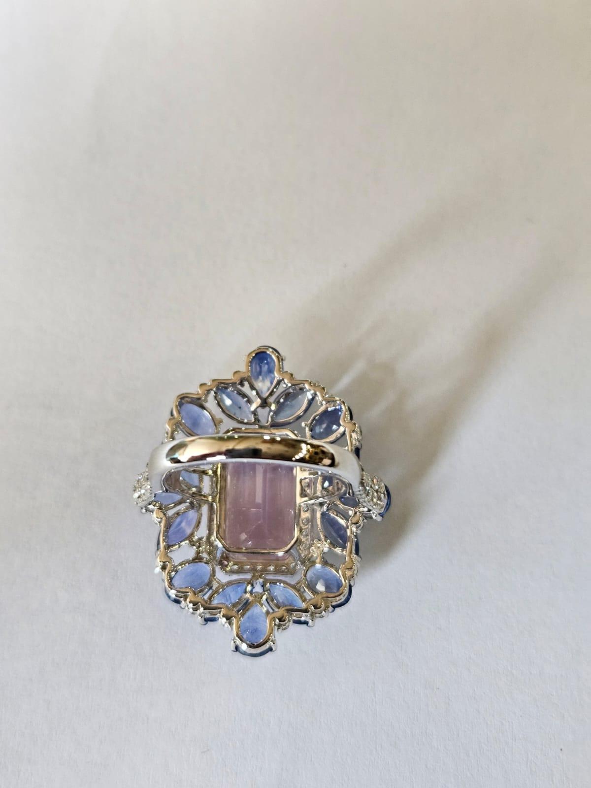 Magnifique bague cocktail en or blanc 18 carats et diamants naturels, de style moderne, ornée de kunzite et de saphirs bleus. Le poids de la kunzite est de 7.99 carats. Le poids des saphirs bleus est de 7.80 carats. Les saphirs bleus sont