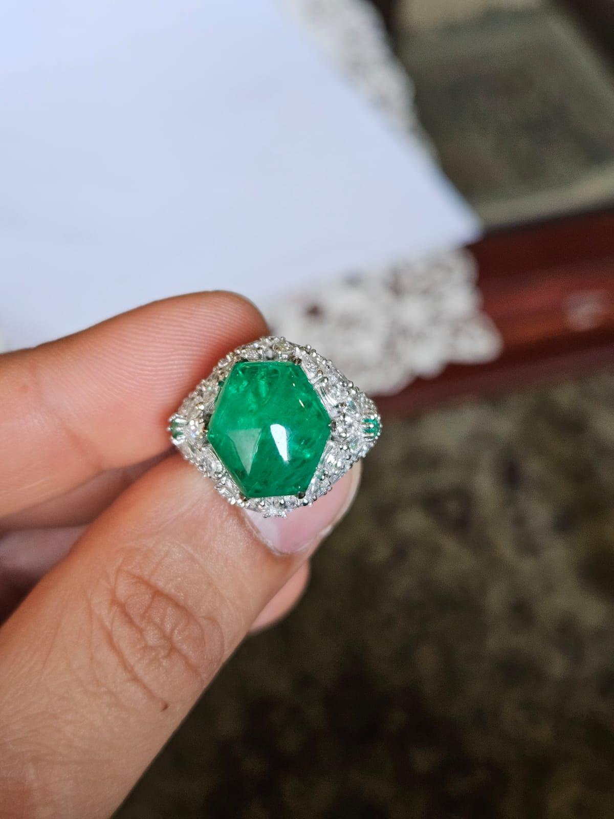 Une très belle bague de fiançailles en or blanc 18 carats et diamants naturels, unique en son genre. Le poids de l'émeraude Sugarloaf est de 8.08 carats. Les autres émeraudes pèsent 0,10 carats. Les émeraudes sont entièrement naturelles, sans aucun