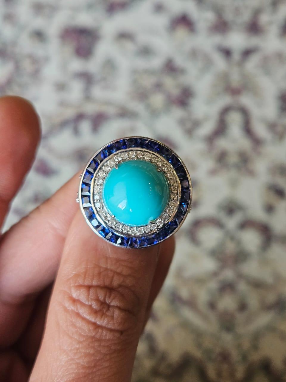 A very beautiful and unique, Turquoise & Blue Sapphire Cocktail Ring set in 18K White Gold & Diamonds. The weight of the Turquoise is 8.65 carats. The Blue Sapphires weight is 2.75 carats. The Blue Sapphires are of Ceylon (Sri Lanka) origin. The