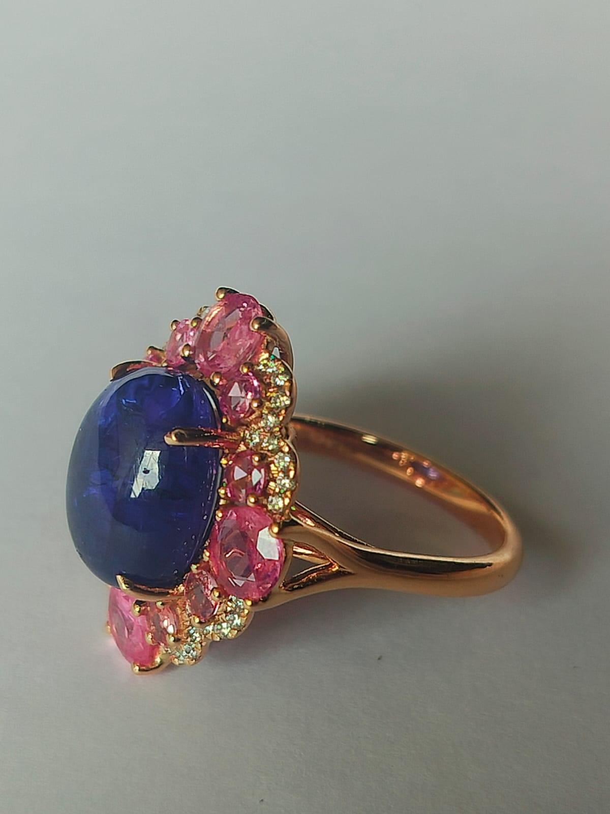 A very gorgeous and one of a kind, Tanzanite Pink Sapphire Cocktail Ring set in 18K Gold & Diamonds. The weight of the Tanzanite cabochon is  9.00 carats. The Tanzanite is responsibly sourced from Tanzania. The weight of the Pink Sapphire is 2.36