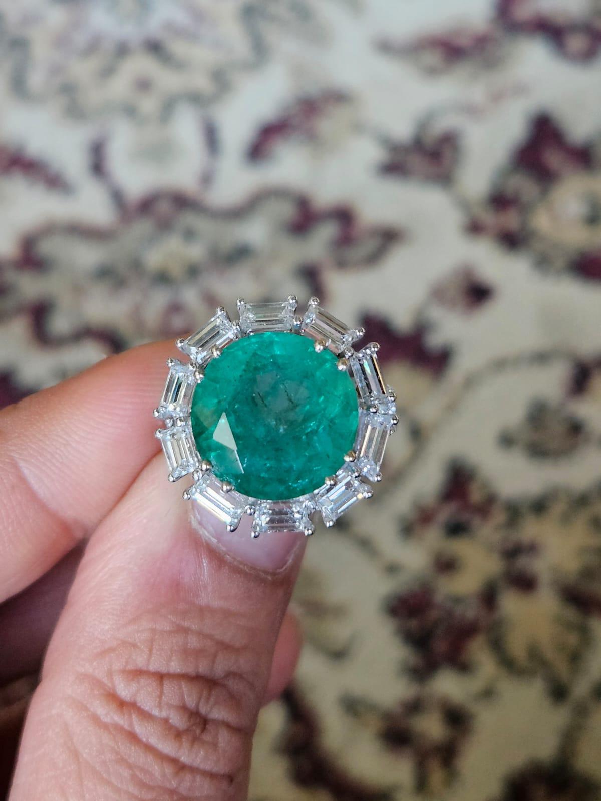 A very stunning and one of a kind, Emerald Engagement Ring set in 18K White Gold & Diamonds. The weight of the round Emerald is 9.49 carats. The Emerald is completely natural, without any treatment and is of Zambian origin. The combined weight of
