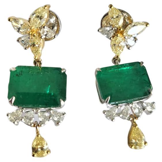 A very gorgeous and modern, Emerald Dangle Earrings set in 18K Gold & Diamonds. The weight of the Emeralds is 9.88 carats. The Emeralds are completely natural, without any treatment and is of Zambian origin. The weight of the pear shaped Diamonds is