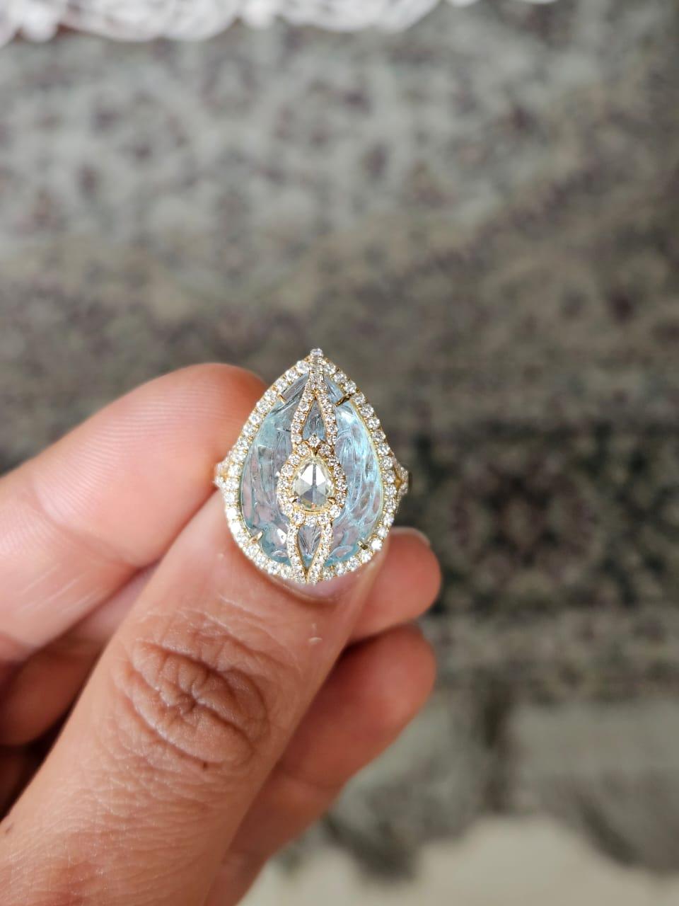 A very gorgeous and beautiful, modern style, Aquamarine Cocktail Ring set in 18K Yellow Gold & natural Diamonds. The weight of the carved Aquamarine is 12.22 carats. The Aquamarine is hand carved in our very own workshop. The combined Diamonds