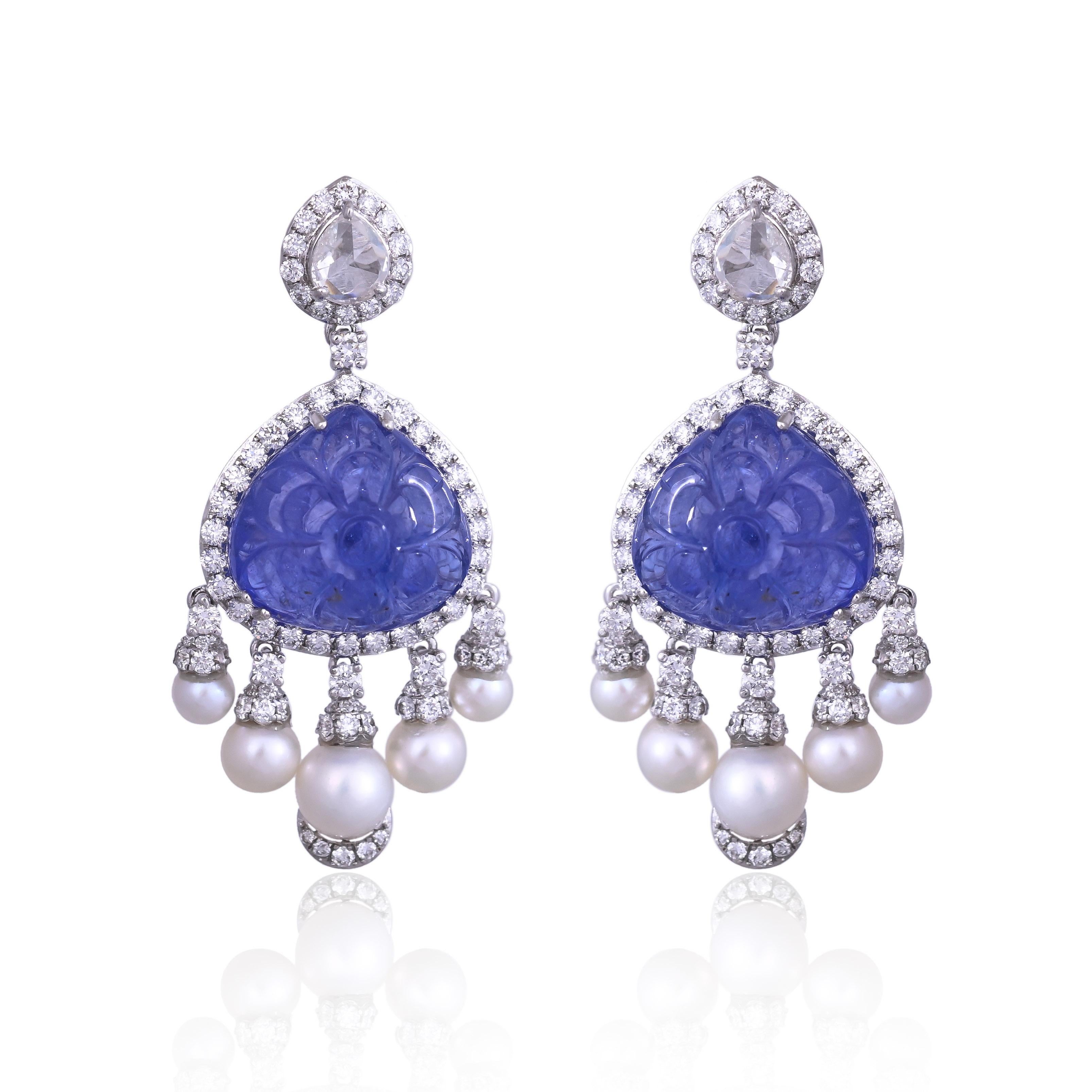 Magnifiques boucles d'oreilles pendantes en or blanc 18 carats et diamants naturels, composées de Tanzanites et de perles d'eau douce, de style moderne. Le poids des tanzanites sculptées est de 19.13 carats. Les tanzanites proviennent de Tanzanie et