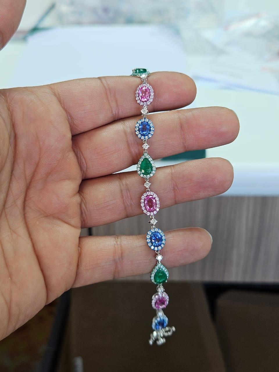 Un très beau bracelet de style moderne en or 18 carats et diamants naturels, composé de saphirs bleus, d'émeraudes et de saphirs roses. Le poids des saphirs bleus est de 1.73 carats. Le poids des saphirs roses est de 1.96 carats. Le poids de