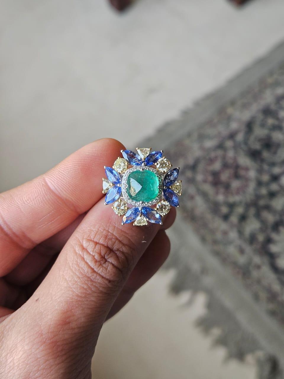 A very gorgeous and beautiful, modern style Emerald & Blue Sapphires Cocktail Ring set in 18K White Gold & natural Diamonds. The weight of the Emerald sugarloaf is  6.53 carats. The Emerald is completely natural, without any treatment and is of