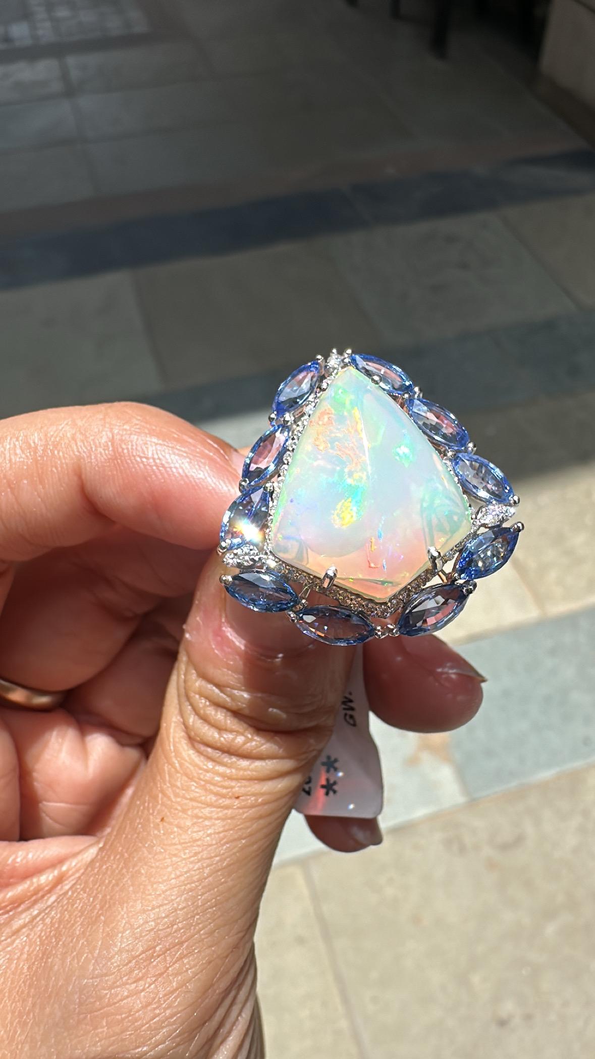 A very gorgeous and beautiful, one of a kind, modern style, Opal & Blue Sapphires Cocktail Dome Ring set in 18K White Gold & natural Diamonds. The weight of the Ethiopian Opal is 10.31 carats. The Opal has a beautiful green and orange play of