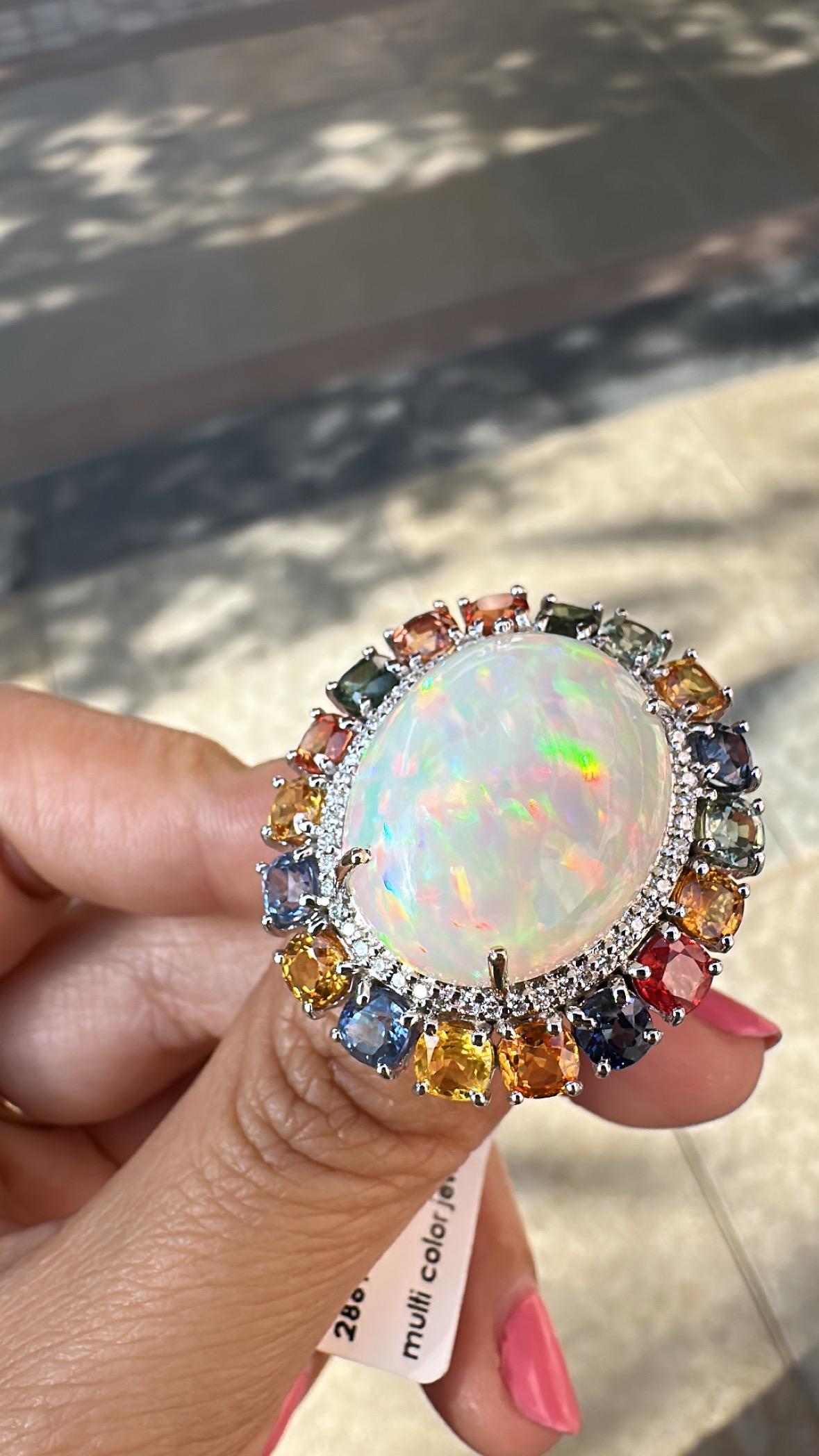A very gorgeous and beautiful, modern style, Ethiopian Opal & Multi Sapphires Cocktail Ring set in 18K White Gold & natural Diamonds. The weight of the Ethiopian Opal is 13.86 carats. The Opal has a orange - green play of colour. The weight of the