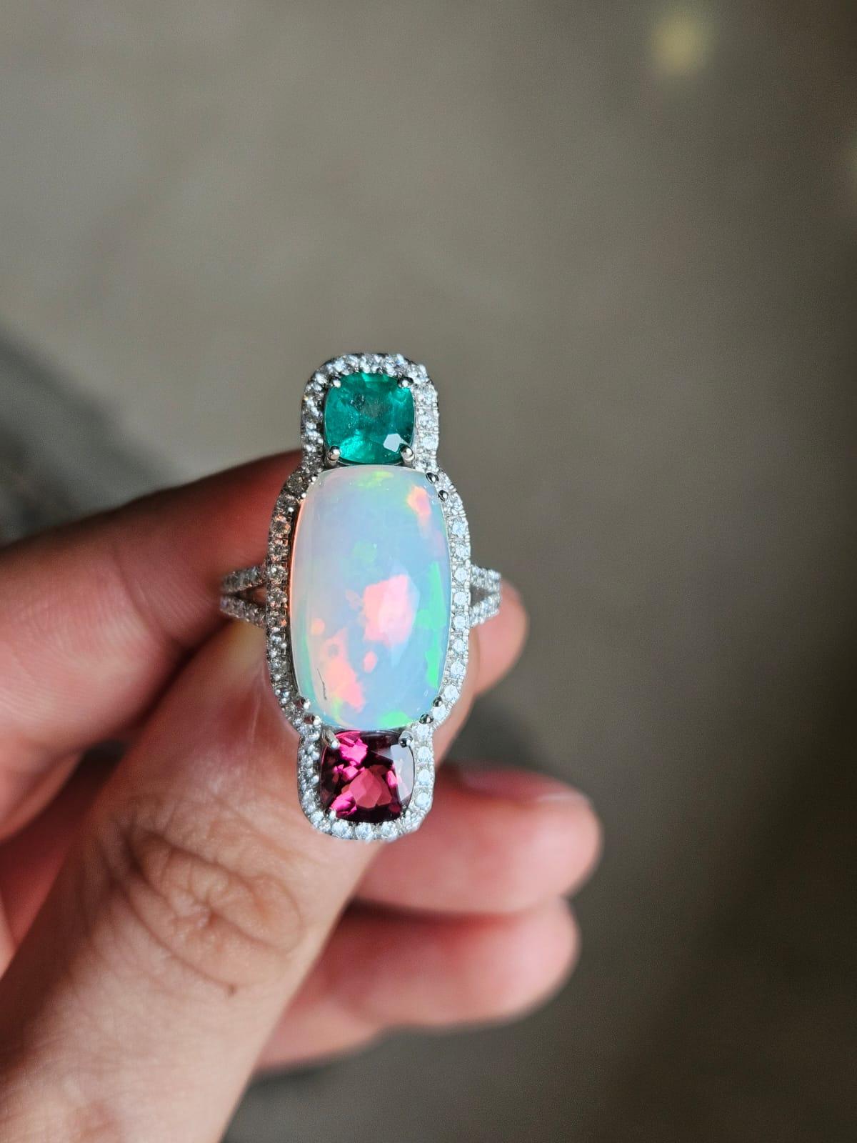 A very gorgeous and beautiful, Opal, Emerald & Rubellite Cocktail Ring set in 18K White Gold & natural Diamonds. The weight of the Ethiopian Opal is 8.03 carats. The weight of the Emerald is 0.91 carats. The Emerald is completely natural, without