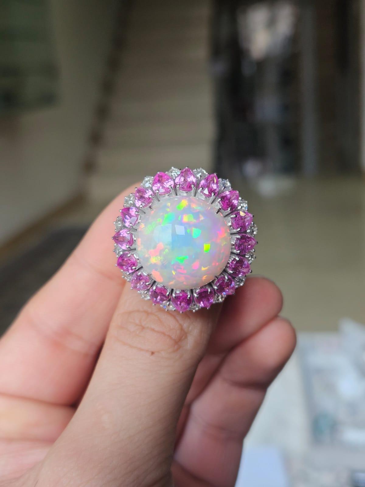 A very gorgeous and beautiful, modern style, Ethiopian Opal & Pink Sapphires Cocktail Dome Ring set in 18K White Gold & natural Diamonds. The weight of the Ethiopian Opal is 12.54 carats. The weight of the Pink Sapphires is 7.21 carats. The Pink