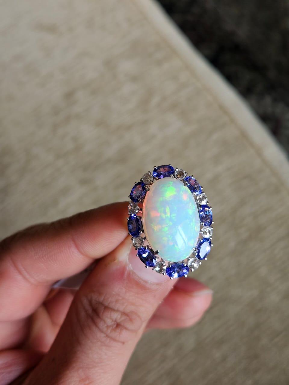 A very gorgeous and beautiful, modern style Opal & Tanzanite Cocktail Engagement Ring set in 18K White Gold & Diamonds. The weight of the Opal is 9.20 carats. The Opal is of Ethiopian origin. The Tanzanite weight is 2.12 carats. The Tanzanites are