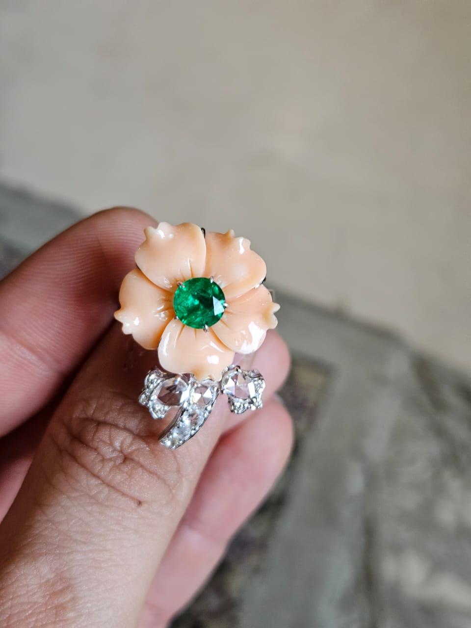 A very beautiful & gorgeous, Coral & Emerald Cocktail Ring set in 18K White Gold & Diamonds. The weight of the carved Coral is 12.42 carats. The Coral is completely natural and is  without any treatment. The weight of the Emerald is 0.81 carats. The