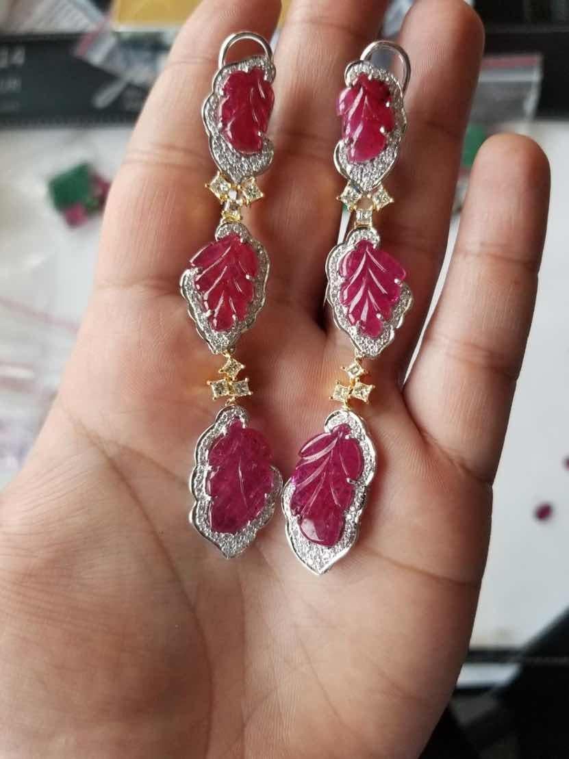 Beautifully set in a melange of yellow and white gold, natural Mozambique carved ruby and diamond earrings. Total weight of ruby is 27.07 carats and diamonds 2.39 carats. The earrings have a simple clip and pull - push mechanism for added protection.