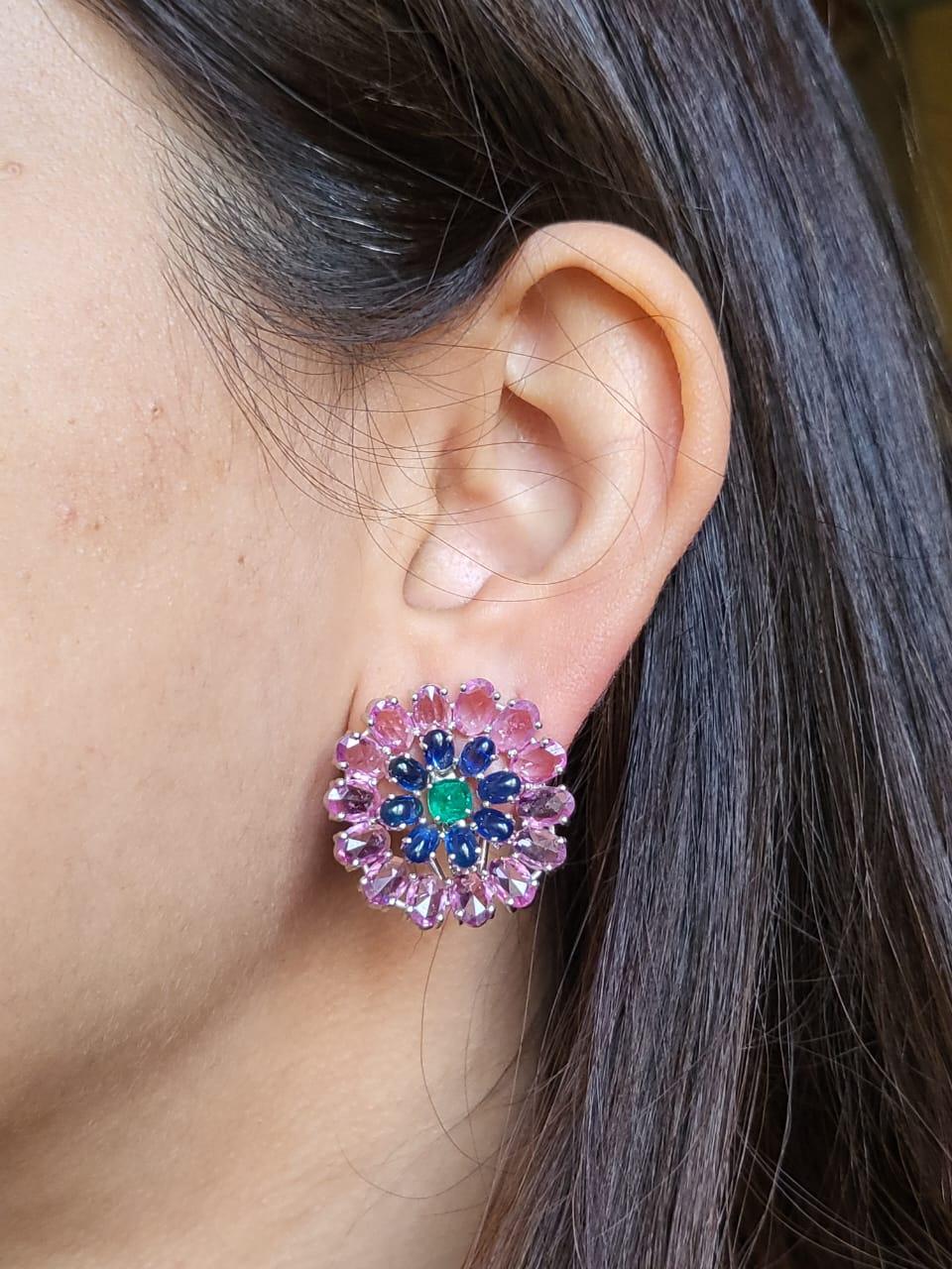 A very gorgeous and one of a kind, Emerald, Blue Sapphires & Pink Sapphires Stud Earrings set in 18K White Gold & Diamonds. The weight of the Emerald Sugarloaf is 0.77 carats. The Emeralds are completely natural without any treatment, and is of