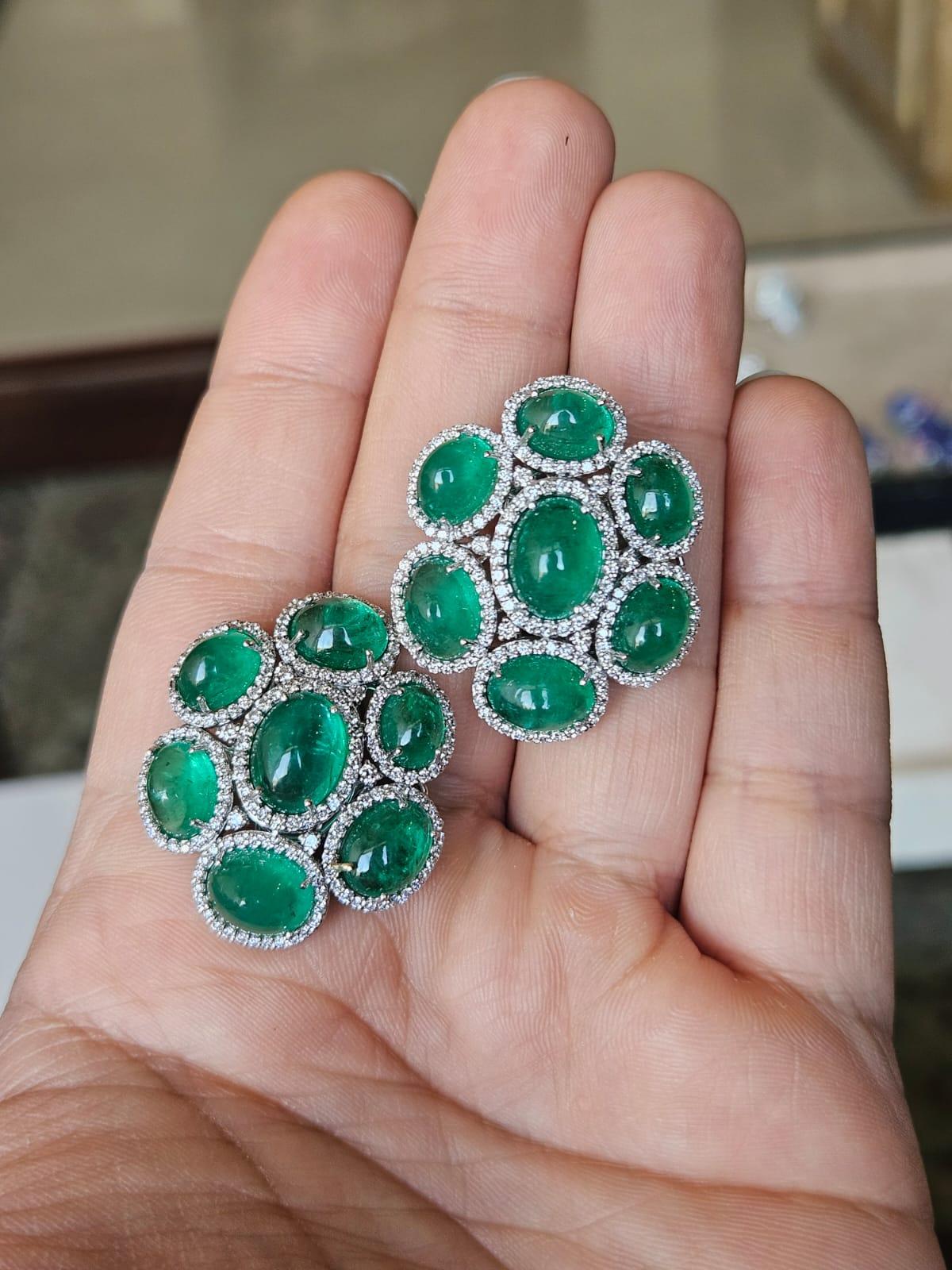 A very gorgeous and beautiful, modern style, Emerald Stud Earrings set in 18K White Gold & natural Diamonds. The weight of the Emerald Cabochons is 26.81 carats. The Emerald Cabochons are completely natural, without any treatment and are of Zambian