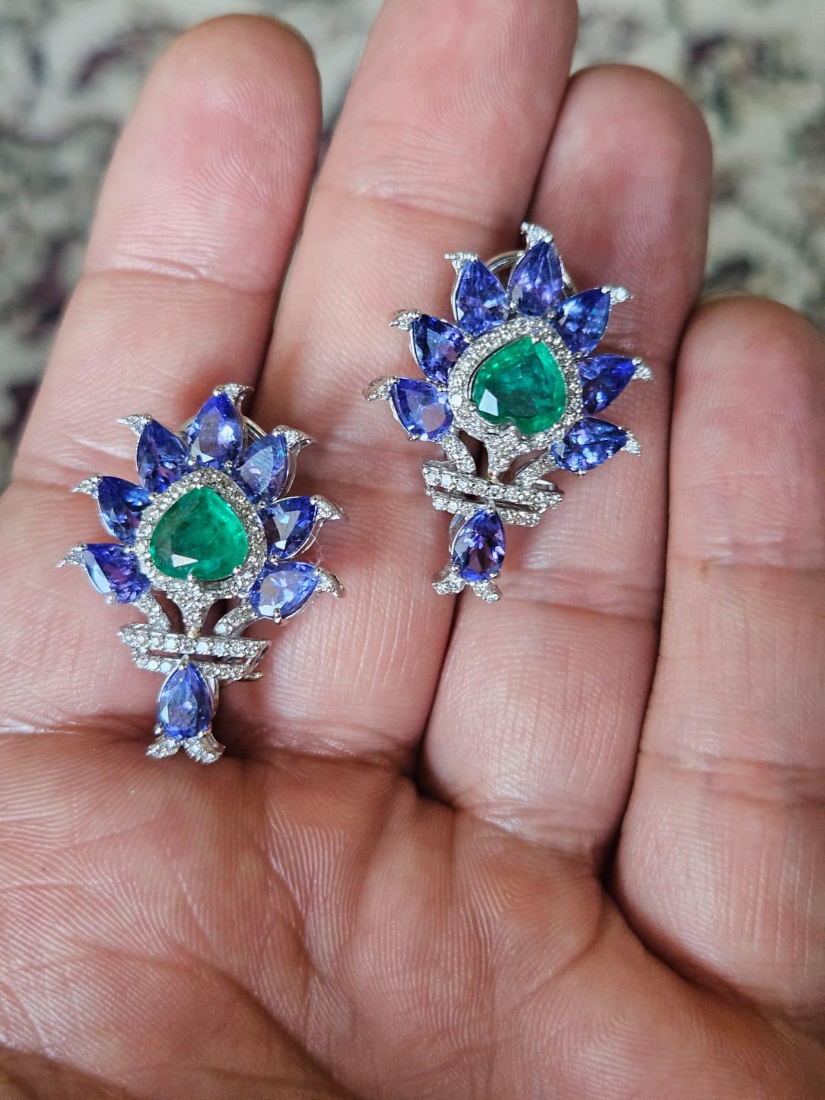 A very gorgeous and one of a kind, modern style, Tanzanite & Emerald Stud Earrings set in 18K White Gold & Diamonds. The weight of the Tanzanites is 6.76 carats. The Tanzanites are responsibly sourced from Tanzania. The weight of the Emeralds is