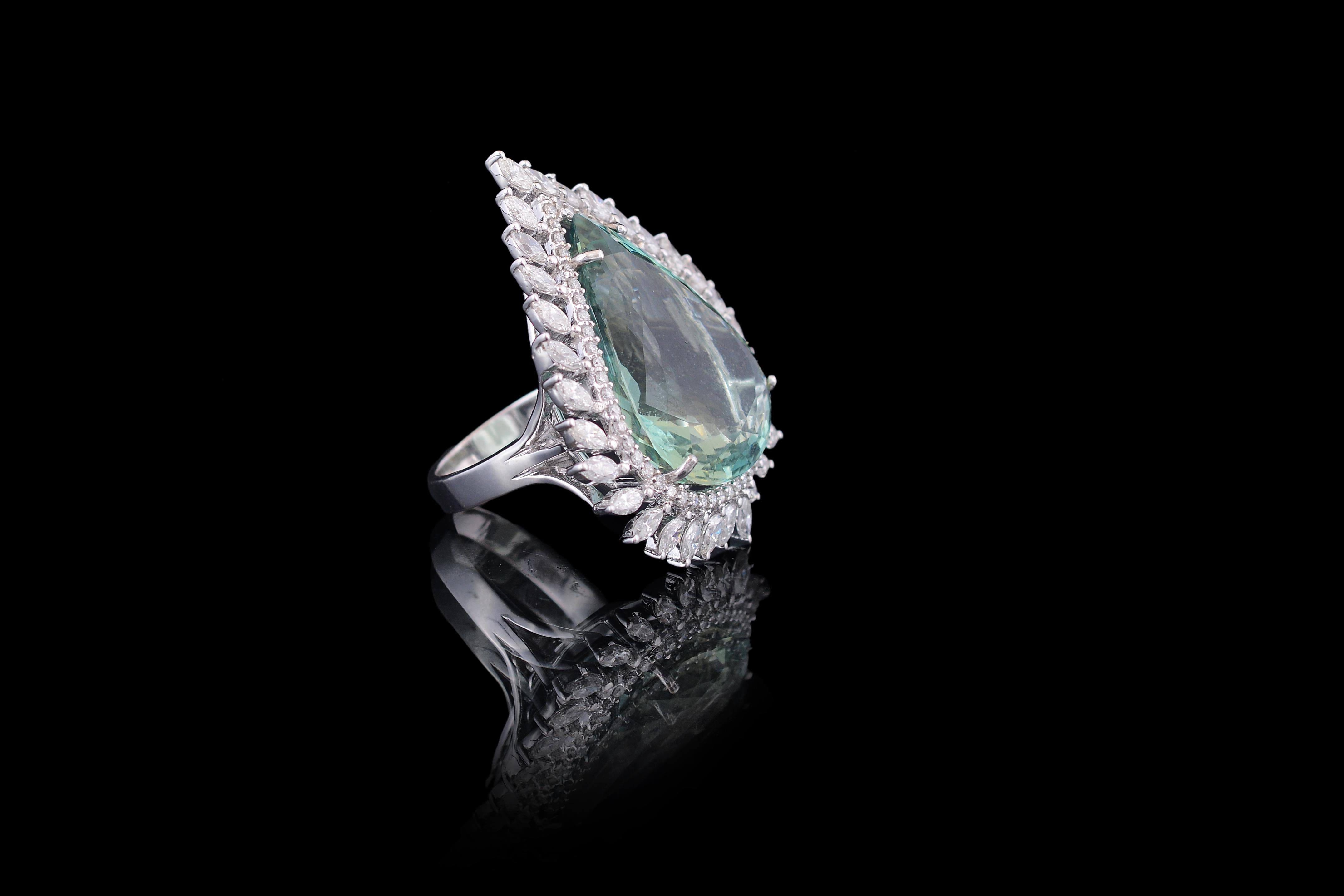 A very gorgeous and chic pear shaped, green aquamarine ring set with marquise shaped diamond in 18K white gold. The weight of the aquamarine is 22.27 carats and the weight of the marquise diamonds is 1.77 carats. The green shade of the aquamarine is
