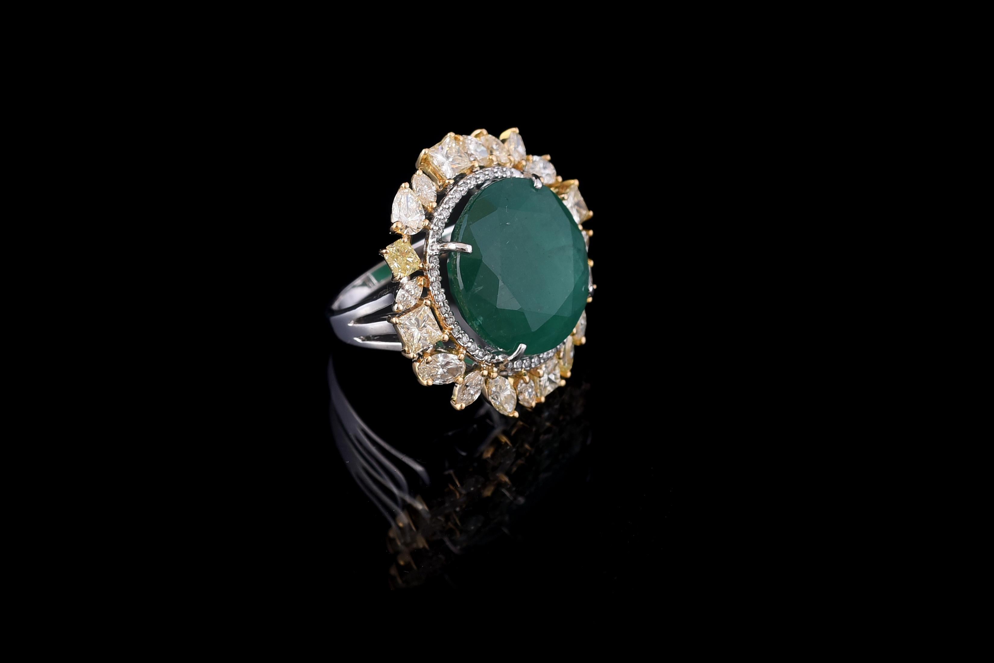 A classic round Emerald Cocktail Ring set in 18K gold with fancy yellow diamonds. The Emerald is of Zambian origin, and is completely natural without any treatment. The weight of the Emerald is 15.70 carats. The combined weight of the diamonds is