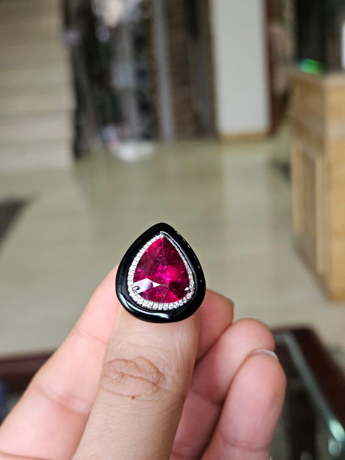 Un bellissimo anello di fidanzamento in stile Art déco con rubellite e onice nera, incastonato in oro 18 carati e diamanti naturali. Il peso della rubellite a forma di pera è di 7.54 carati. Il peso dell'onice nera è di 4.69 carati. Il peso dei