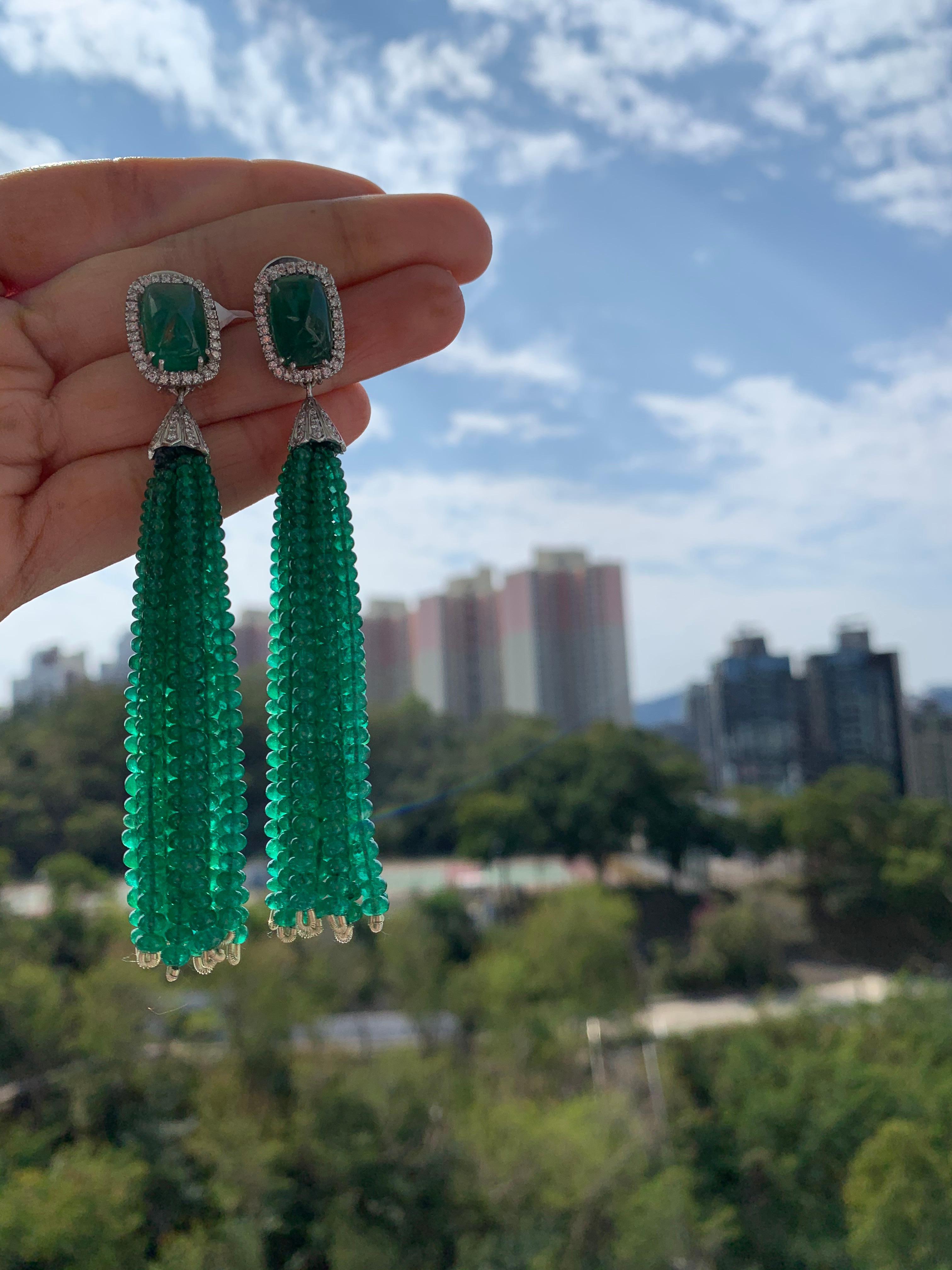 A gorgeous pair of Zambian Emerald Chandelier Tassel Earrings set in 18K Gold & Diamonds. The earrings are set in with Zambian Sugarloaf Emeralds weighing 12.16 carats. The sugarloaf Emerald is completely natural without any treatment. The Zambian