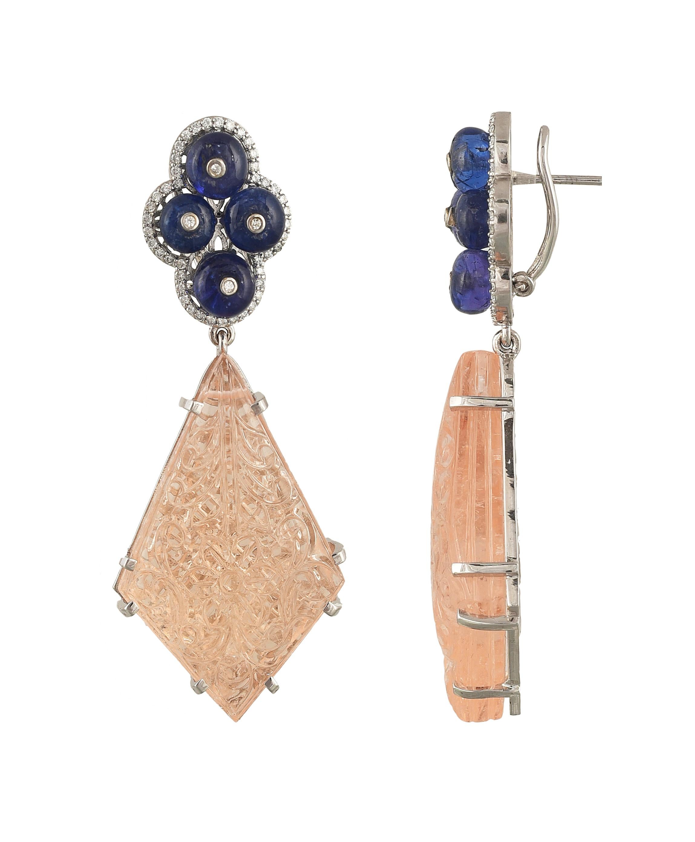 A gorgeous and very different pair of earrings set in 18K gold with diamonds, tanzanite and carved Morganite. The Tanzanite is natural, originating from Tanzania, weighs 22 carats. The Morganite is natural, carved and weighs 128.77 carats in total .