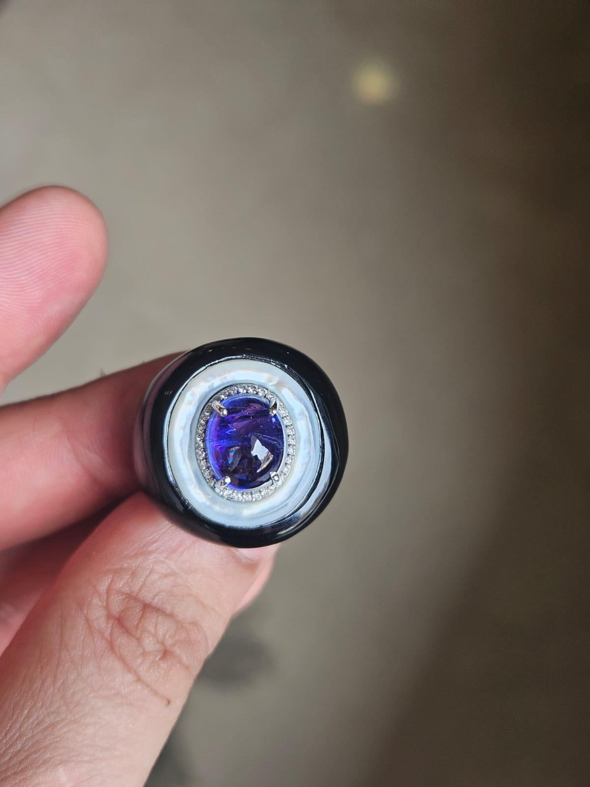 A very gorgeous and beautiful, modern style, Tanzanite, Mother of Pearl & Black Onyx Cocktail Ring set in 18K Gold & natural Diamonds. The weight of the Tanzanite cabochon is 5.02 carats. The Tanzanite cabochon is responsibly sourced from Tanzania.