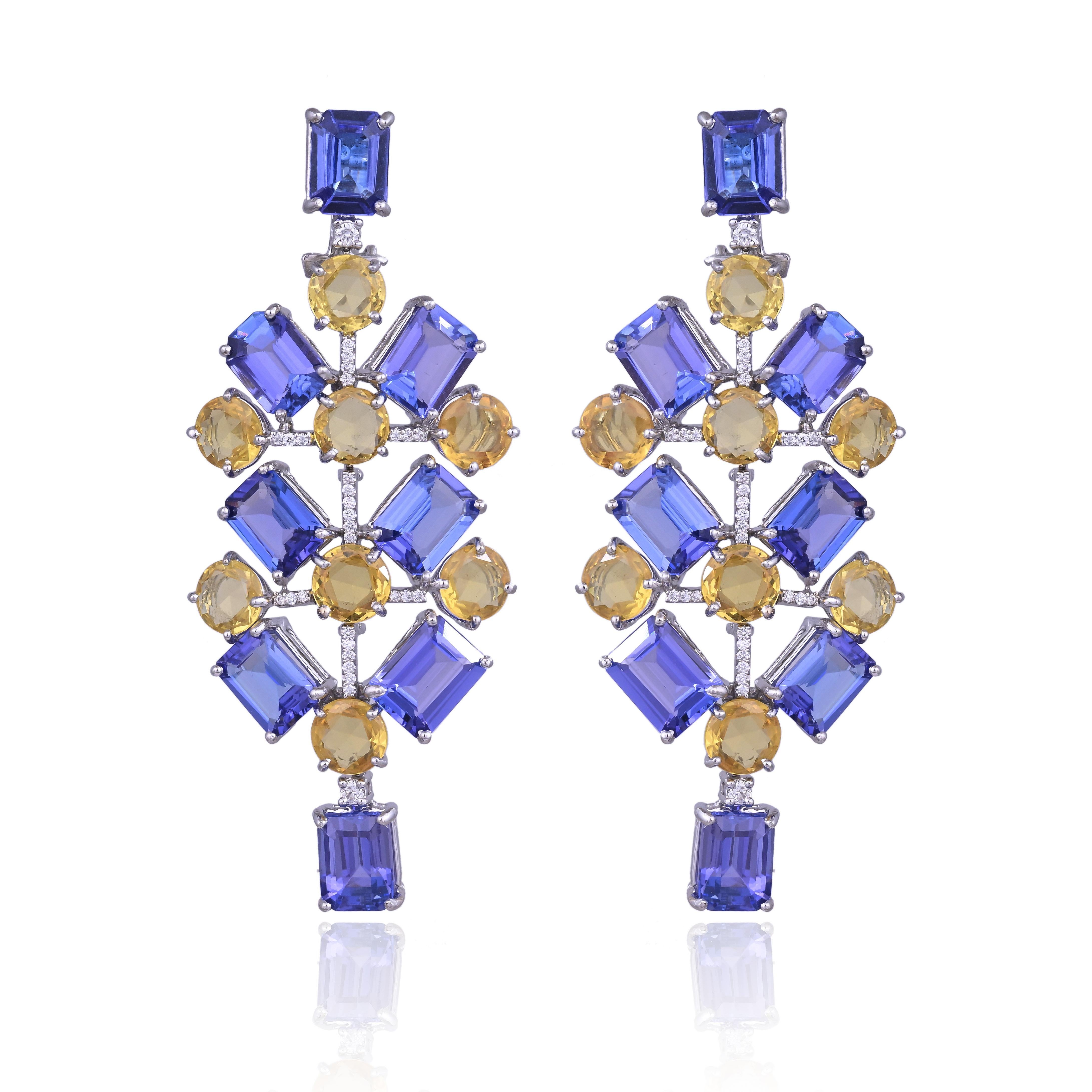 Magnifiques boucles d'oreilles chandelier en or blanc 18 carats et diamants naturels, composées de Tanzanites et de saphirs jaunes, de style moderne. Le poids des tanzanites est de 23.40 carats. Les tanzanites proviennent de Tanzanie. Le poids des