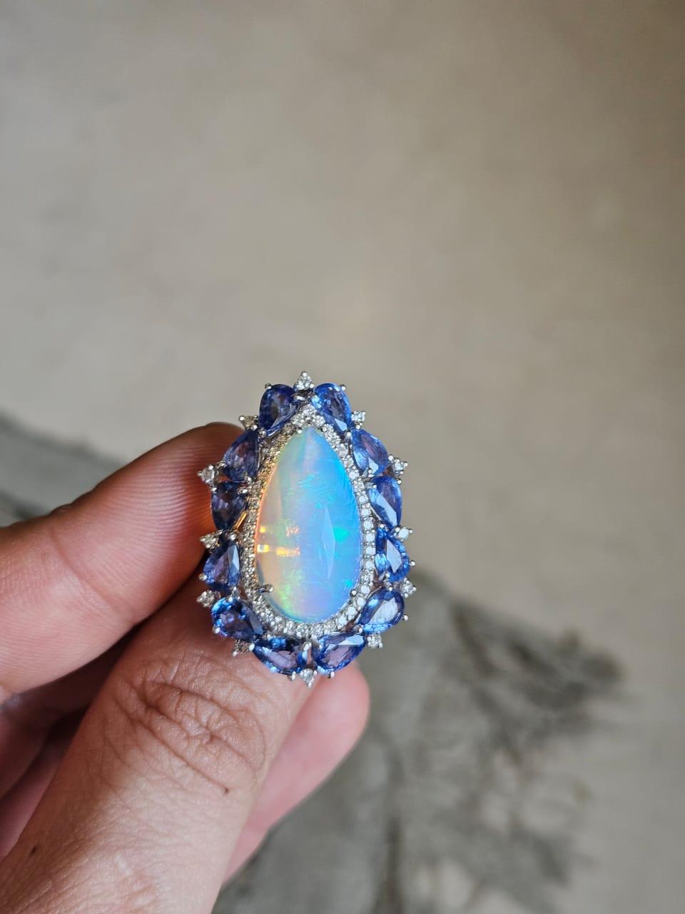 A very gorgeous and beautiful, Ethiopian Opal & Blue Sapphires Cocktail Ring set in 18K White Gold & Diamonds. The weight of the pear shaped cabochon Opal is 6.67 carats. The Opal is of Ethiopian origin and has an blue - green play of colour. The