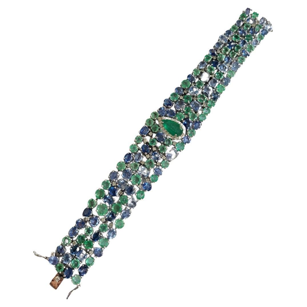 Ein wunderschönes und einzigartiges, modernes Armband aus Smaragd und blauem Saphir in 18 Karat Weißgold und Diamanten. Das Gewicht des Smaragds beträgt 22.30 Karat. Die Smaragde sind völlig natürlich, ohne jegliche Behandlung und sind sambischen