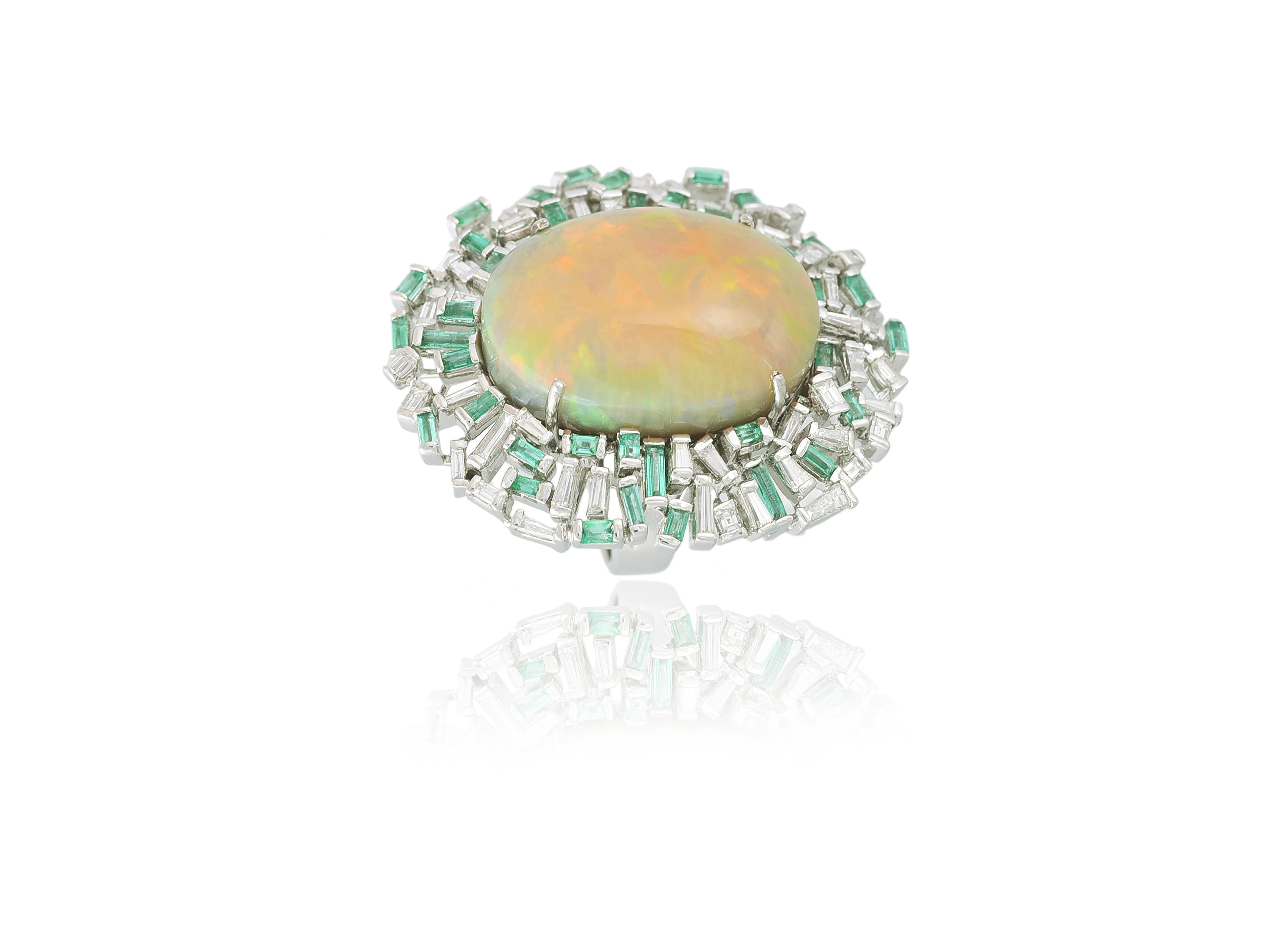 A one of a kind, oversized Ethiopian Opal, Baguette Emeralds & Baguette Diamonds cocktail ring set in 18K gold. The weight of the Ethiopian opal is 31.47 carats. The opal is natural from Ethiopia. The weight of the Emeralds is 1.46 carats. The
