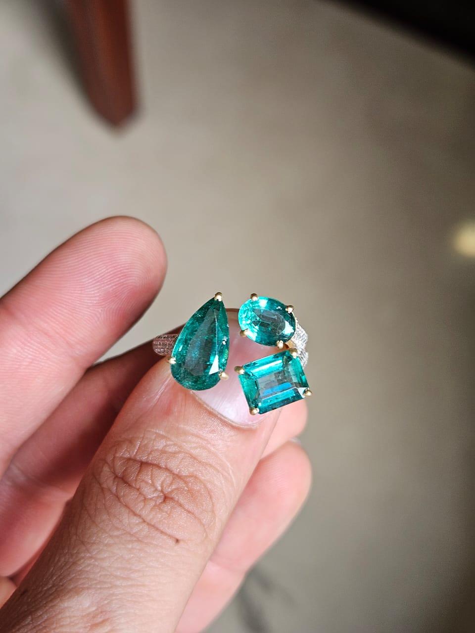 Un precioso anillo de tres piedras con esmeralda, engastado en oro amarillo mate de 18 quilates y diamantes. El peso de las Esmeraldas es de 5,90 quilates. Las esmeraldas son completamente naturales, sin ningún tratamiento y son de origen zambiano.