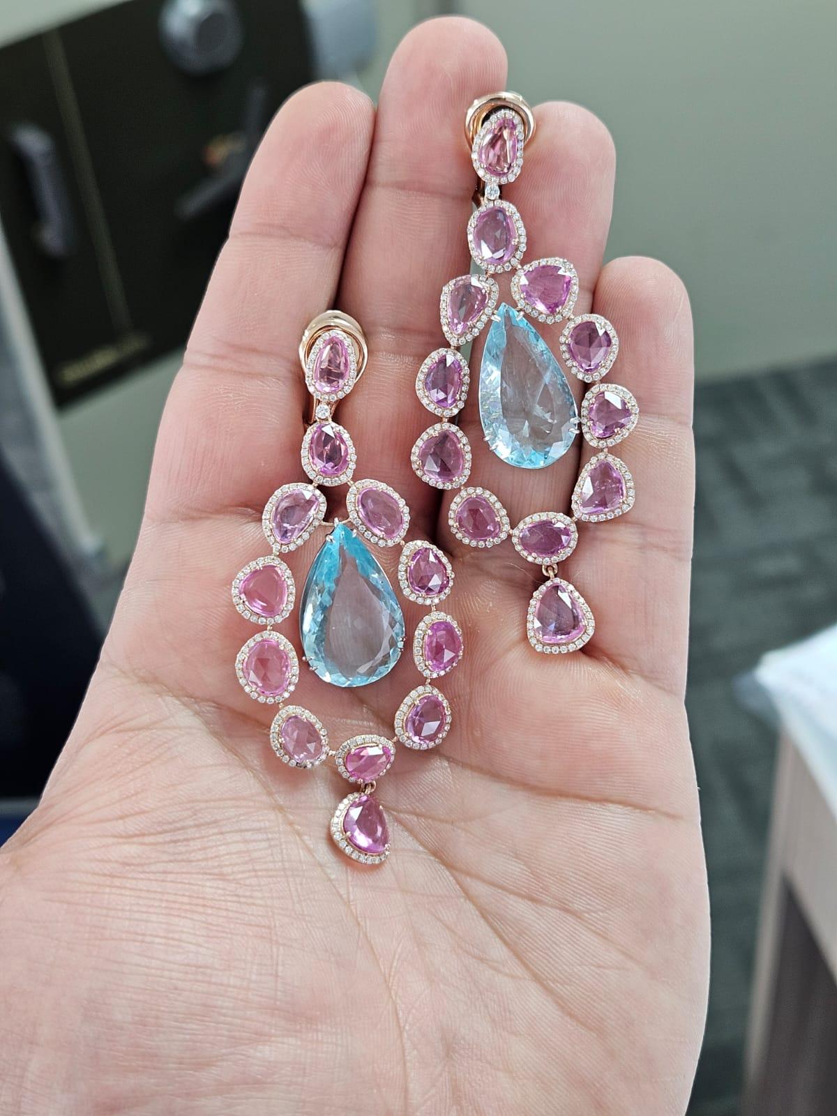 A very beautiful and one of a kind, Aquamarine & Pink Sapphires Chandelier Earrings set in 18K Rose Gold & Diamonds. The weight of the pear shaped Aquamarines is 20.39 carats. The weight of the Pink Sapphire Rose Cuts is 15.88 carats. The Pink