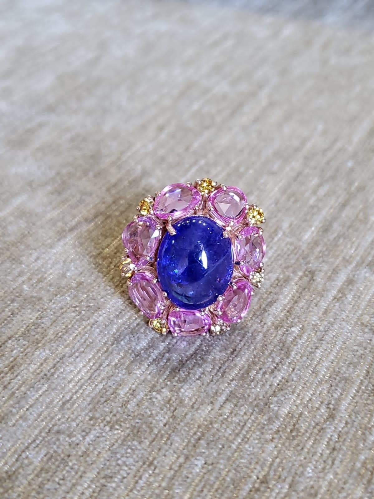 A very gorgeous Tanzanite & Pink Sapphires Cocktail Ring set in 18K Rose Gold & Diamonds. The weight of the Tanzanite Cabochon is 9.21 carats. The Tanzanite is responsibly sourced from Tanzania. The weight of the Pink Sapphires Rose Cuts is 4.71