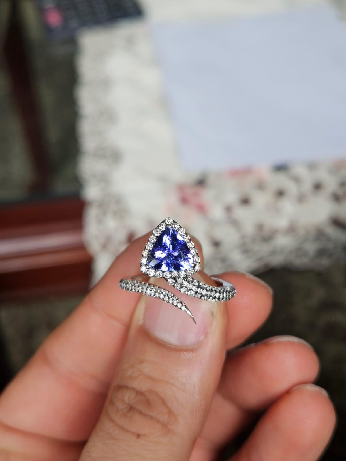Un precioso anillo de compromiso de tanzanita, de estilo moderno, engastado en oro blanco de 18 quilates y diamantes naturales. El peso de la tanzanita es de 1.58 quilates. La tanzanita procede de forma responsable de Tanzania. El peso de los